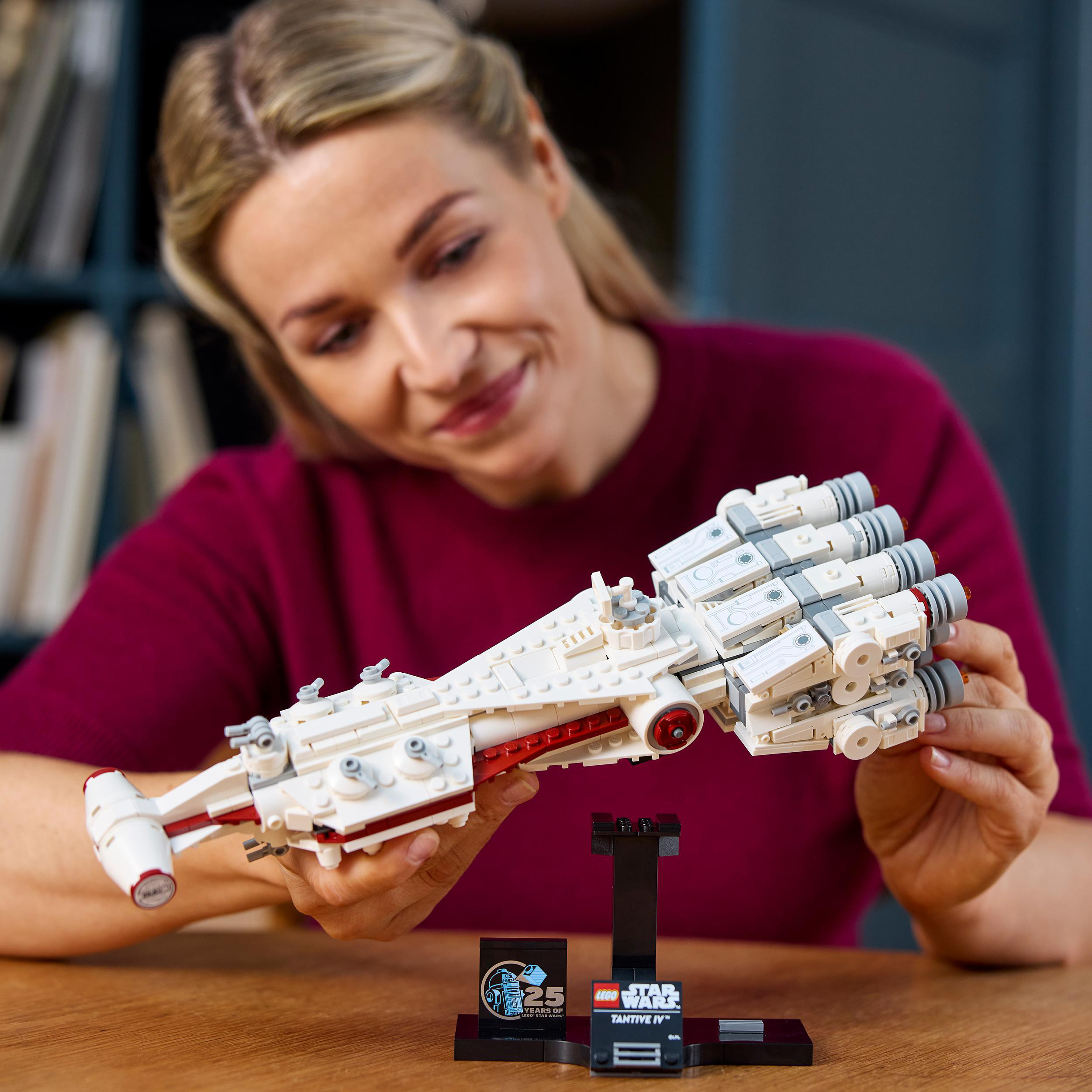 Eine Frau betrachtet ein weißes LEGO Star Wars Modell auf einem schwarzen Ständer.
