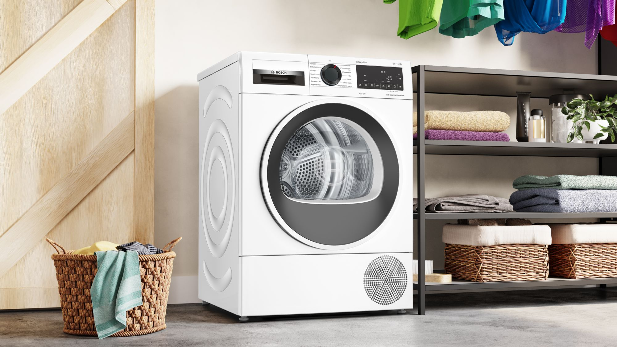 Sèche-linge blanc avec porte ouverte, avec un panier de vêtements et une étagère en arrière-plan.