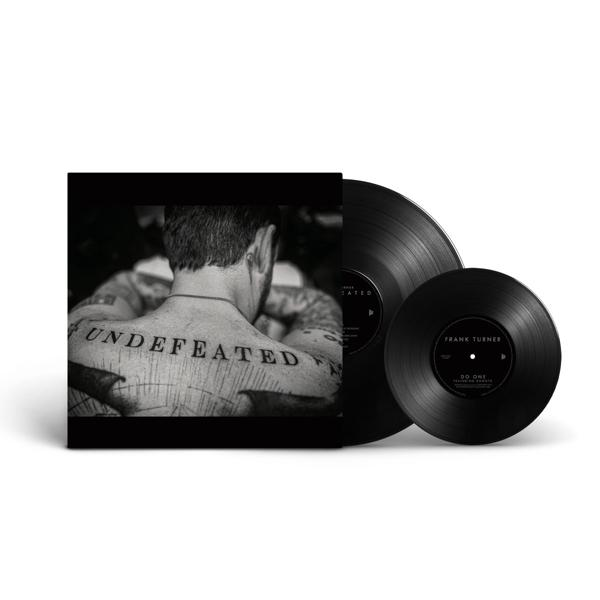 Schallplatte mit dem Rücken einer tätowierten Person, das Wort UNDEFEATED ist auf dem Rücken zu sehen.