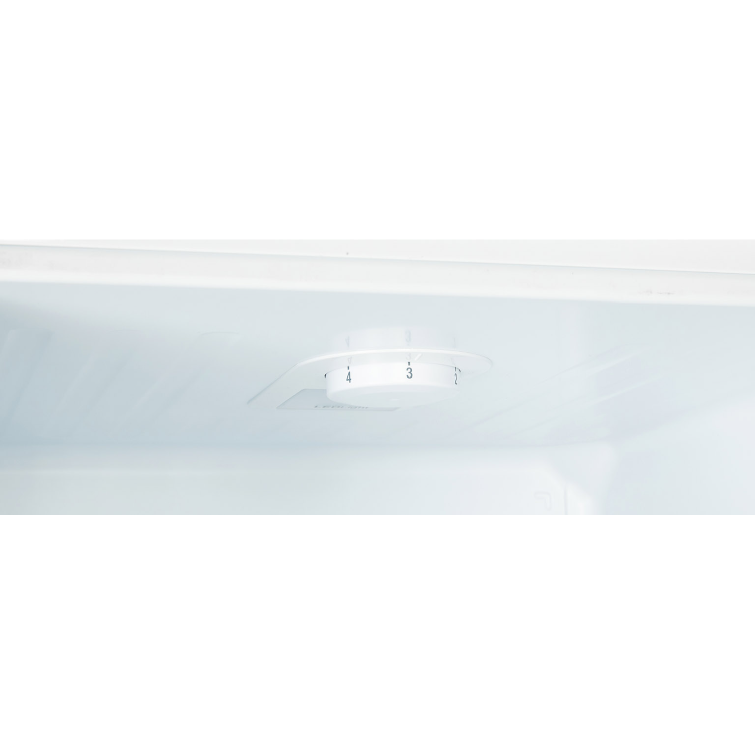 Inside a white refrigerator, a temperature control knob with numbers is visible.