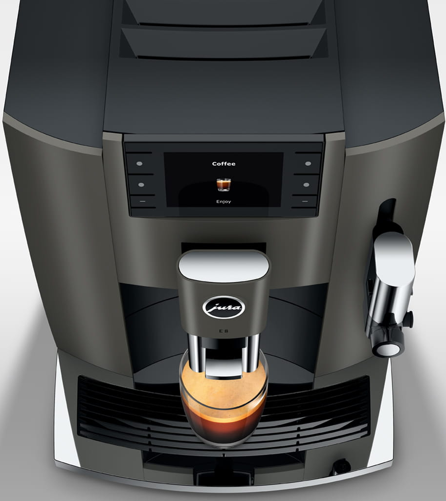 Vista dall'alto di una macchina da caffè scura che versa caffè in un bicchiere. La parola 'Coffee' è visualizzata.