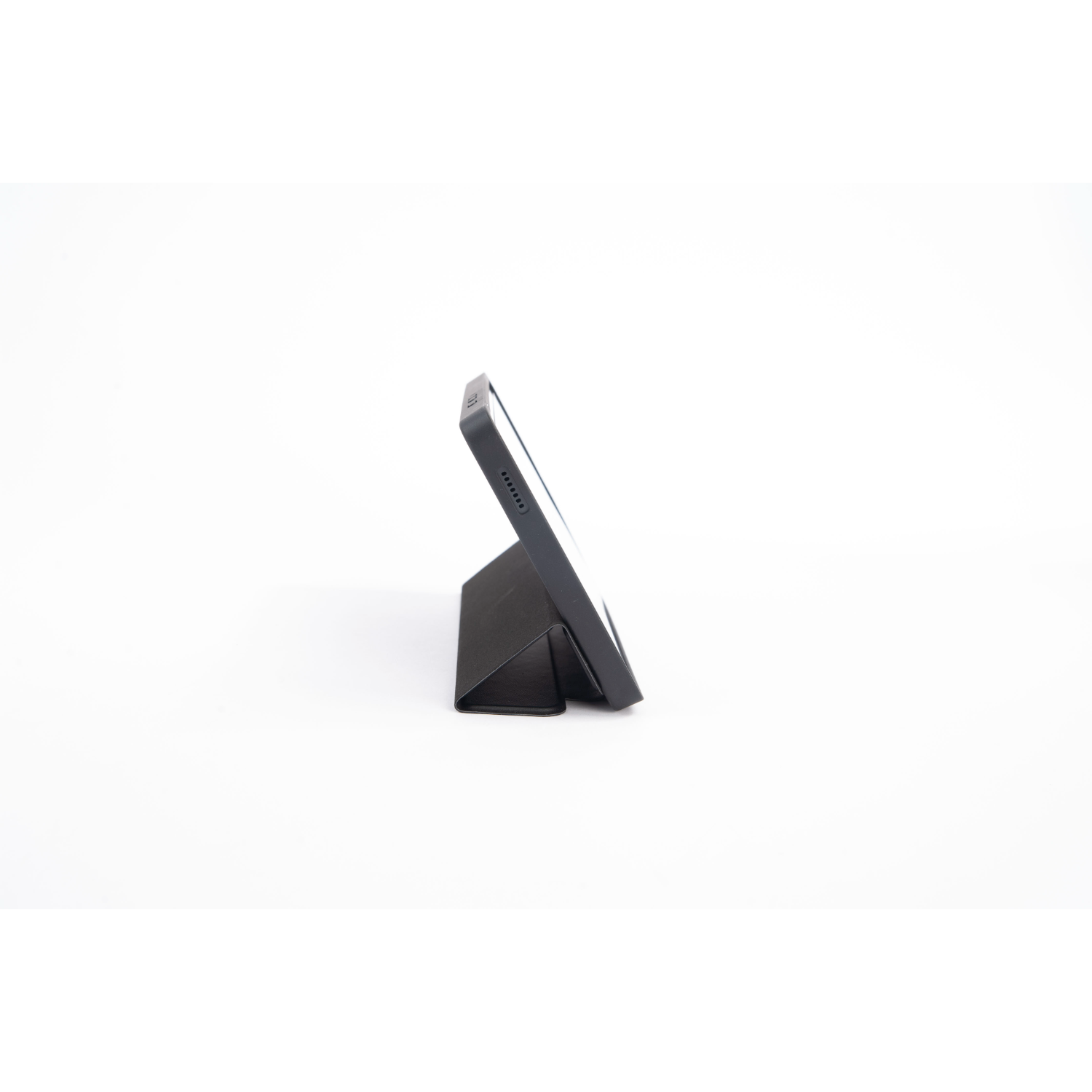 A tablet in a black cover stands upright. The screen is facing forward and the cover is open.