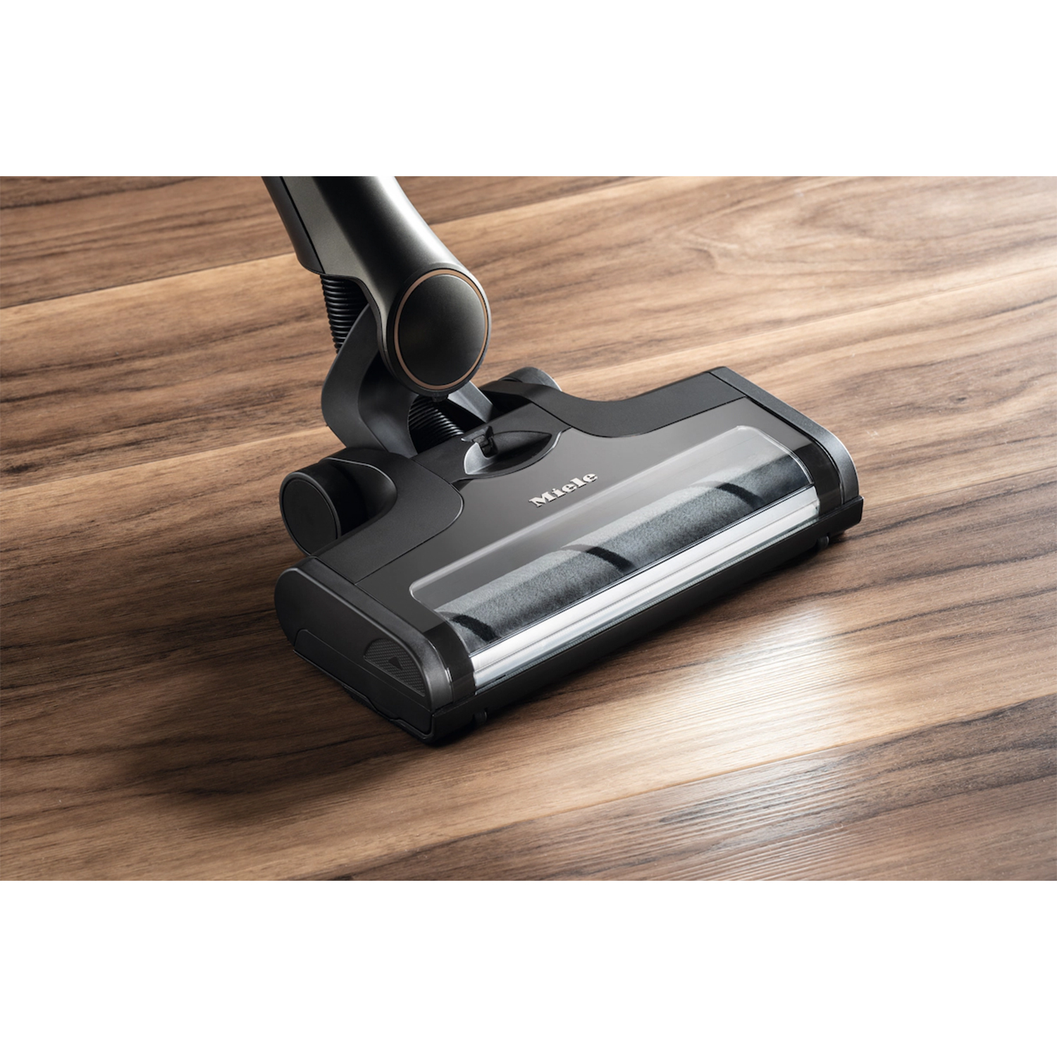 Testa aspirapolvere nera su legno, con scomparto trasparente, marchio Miele.