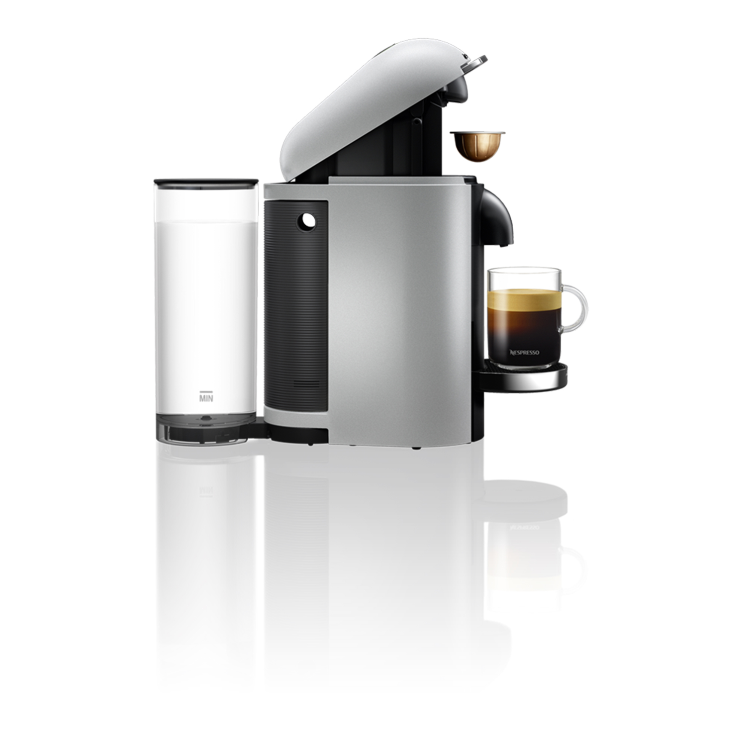 Een zilveren Nespresso-koffiemachine met een glas koffie.