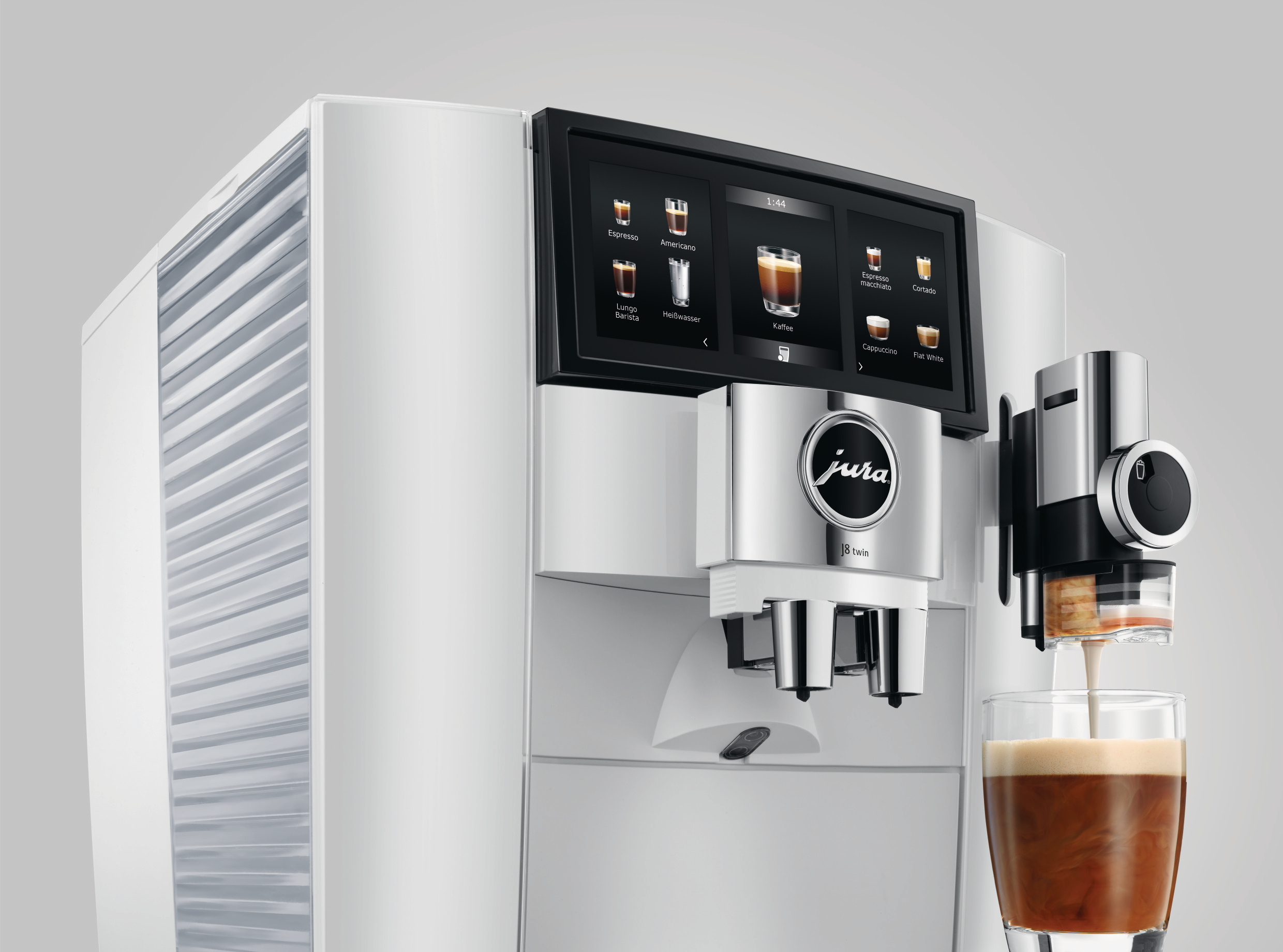 Eine weiße Jura Kaffeemaschine, die Kaffee in ein Glas ausgibt. Ein Touchscreen ist sichtbar.