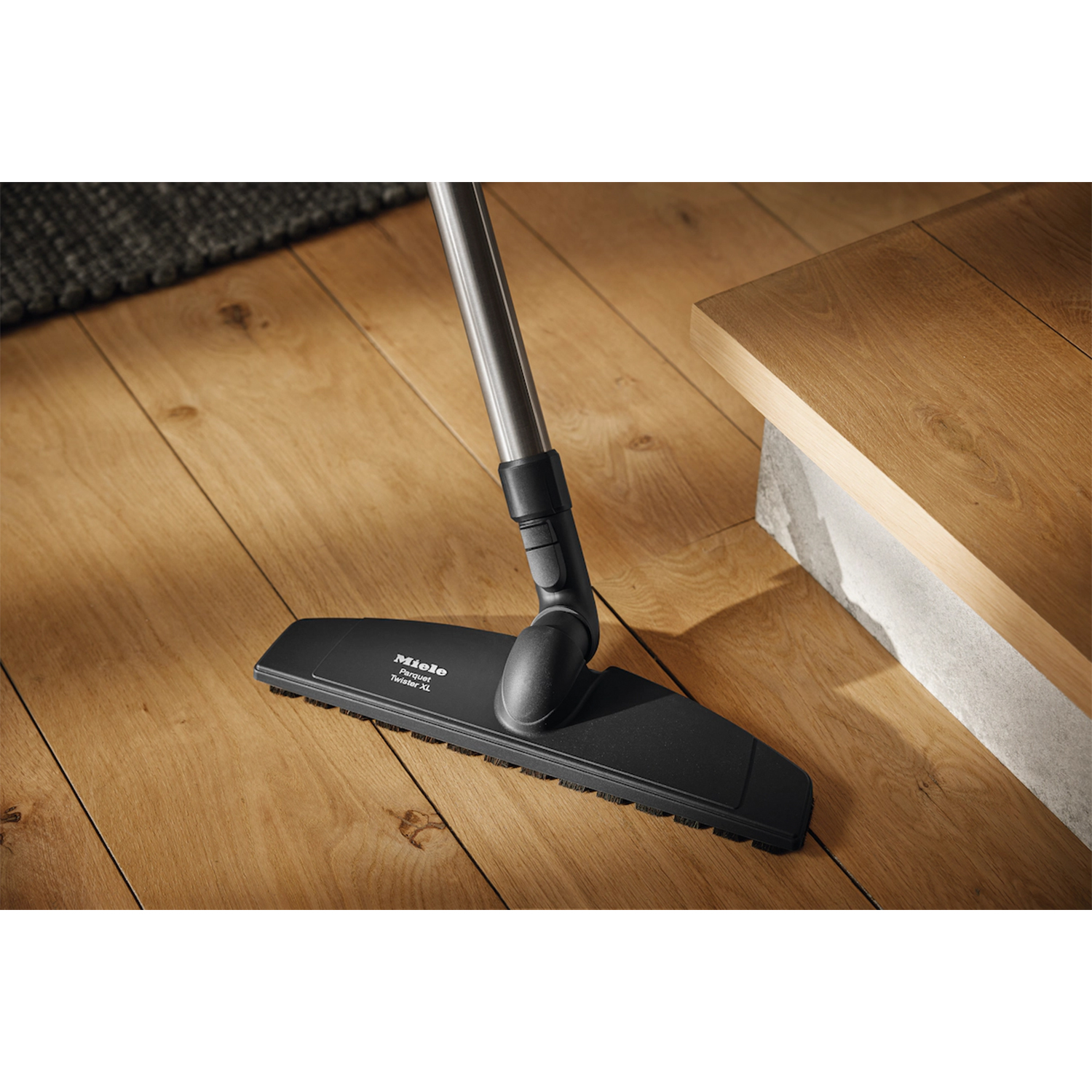 Testa aspirapolvere Miele che pulisce il pavimento in legno.