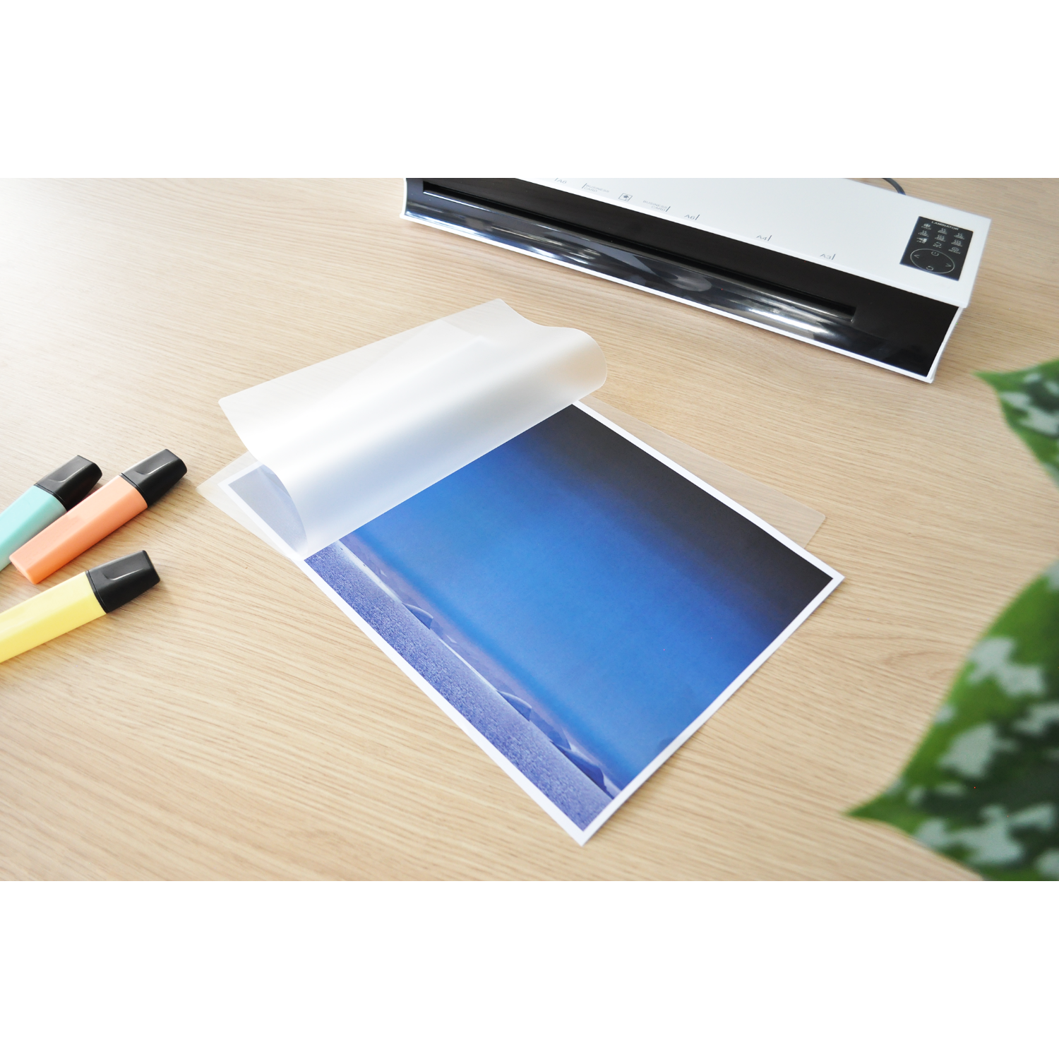 Lamineerapparaat met blauw papier in de transparante plastic folie.