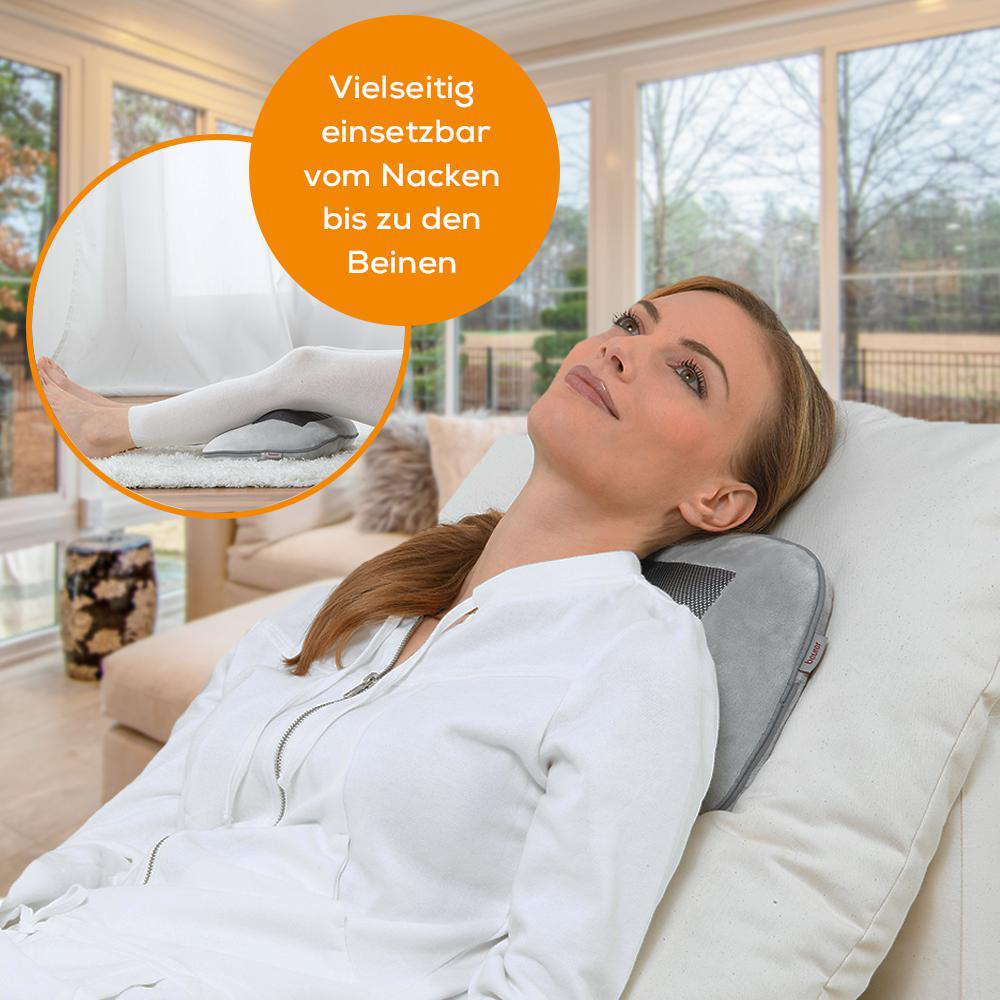 Frau entspannt mit Nacken- und Rückenmassagegerät auf Sofa, Beinauflage im Inset.