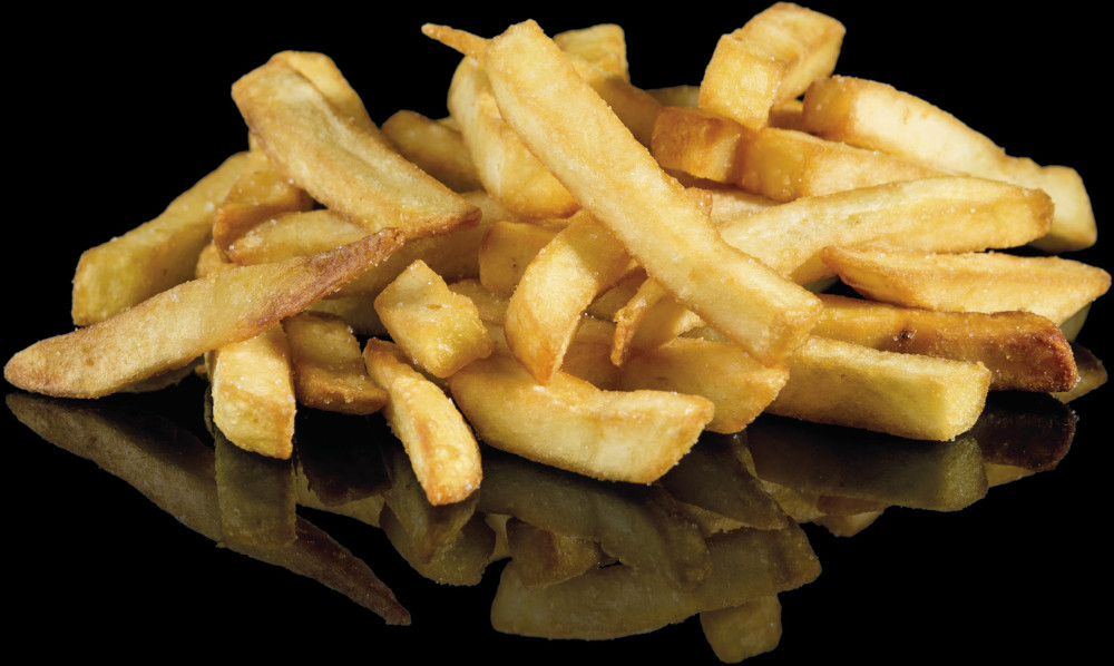 Gouden frites verspreid op een zwart reflecterend oppervlak.