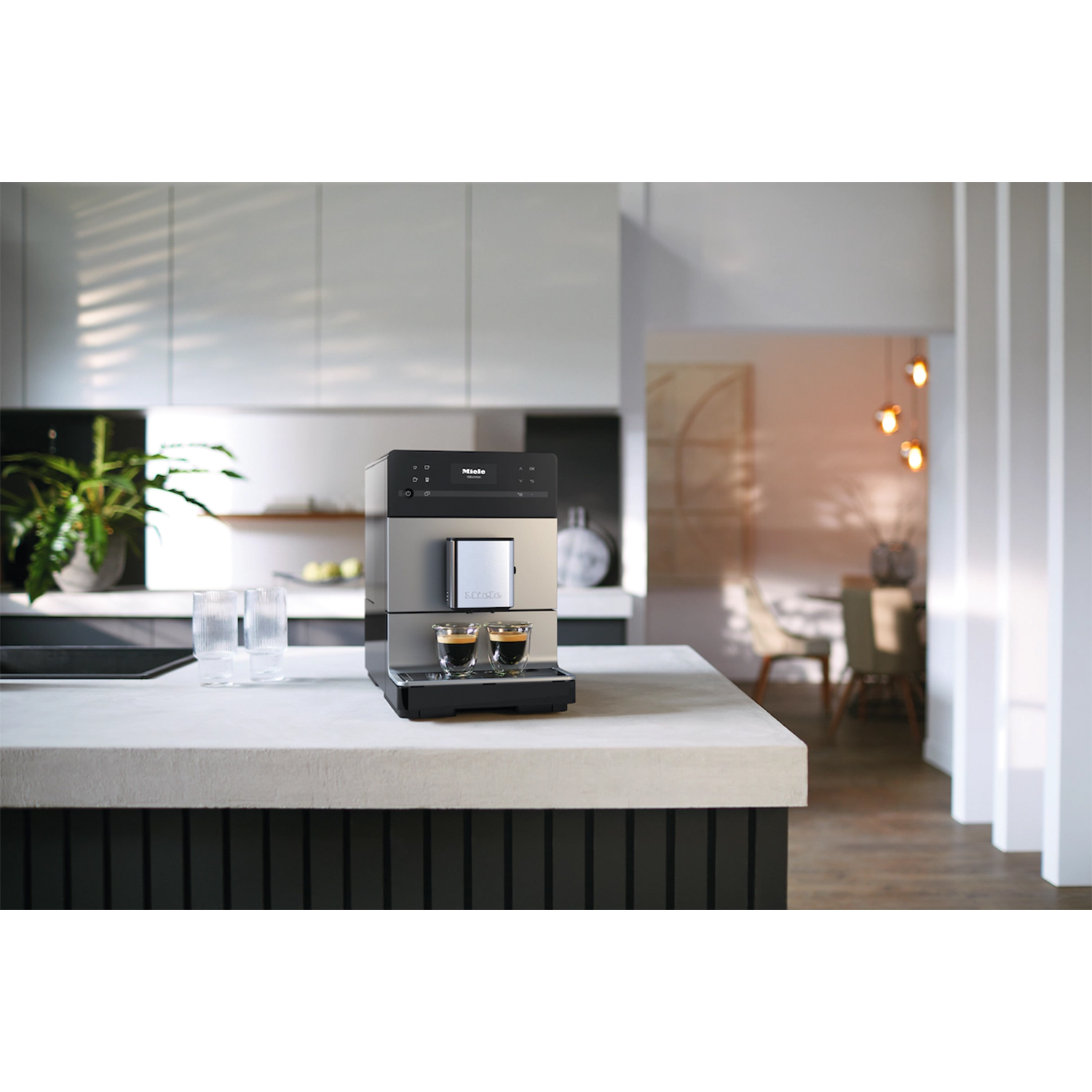 Macchina da caffè su un piano di lavoro con sfondo cucina sfocato.