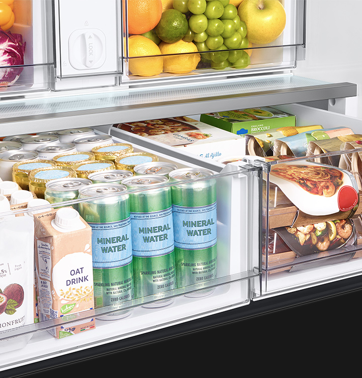 Tiroir de réfrigérateur ouvert rempli de boissons et d'aliments, vue rapprochée.