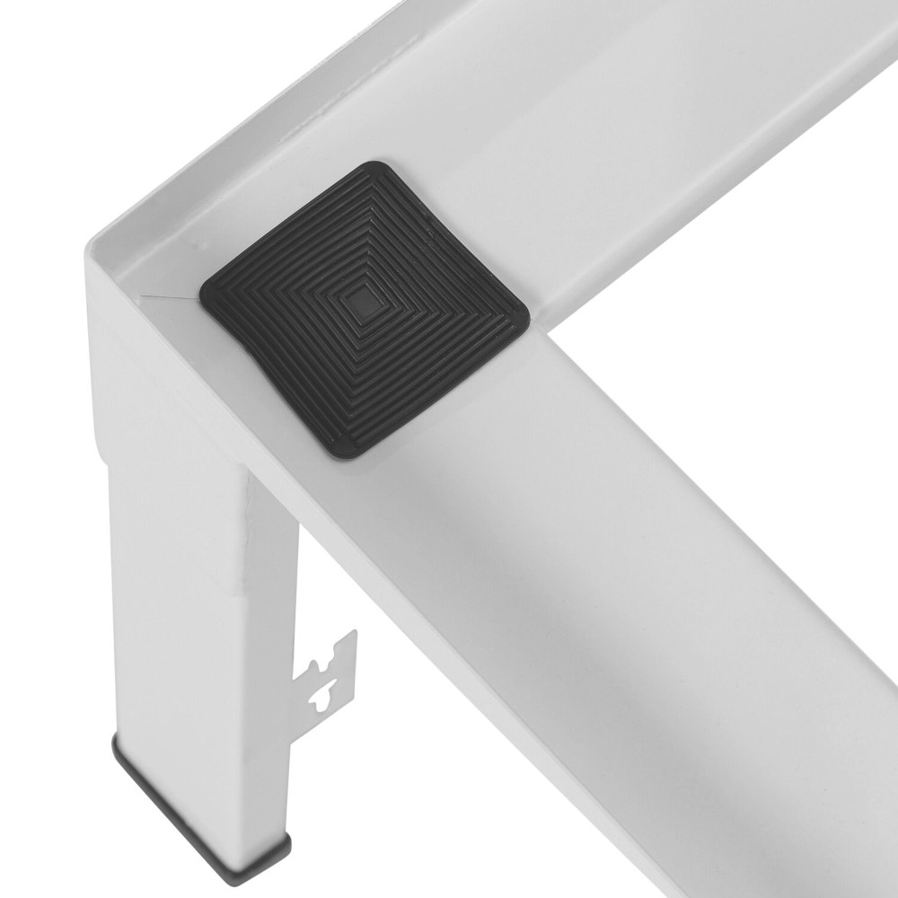 Biały metalowy narożnik z czarną kwadratową gumową podkładką. Narożnik jest częścią większej konstrukcji.