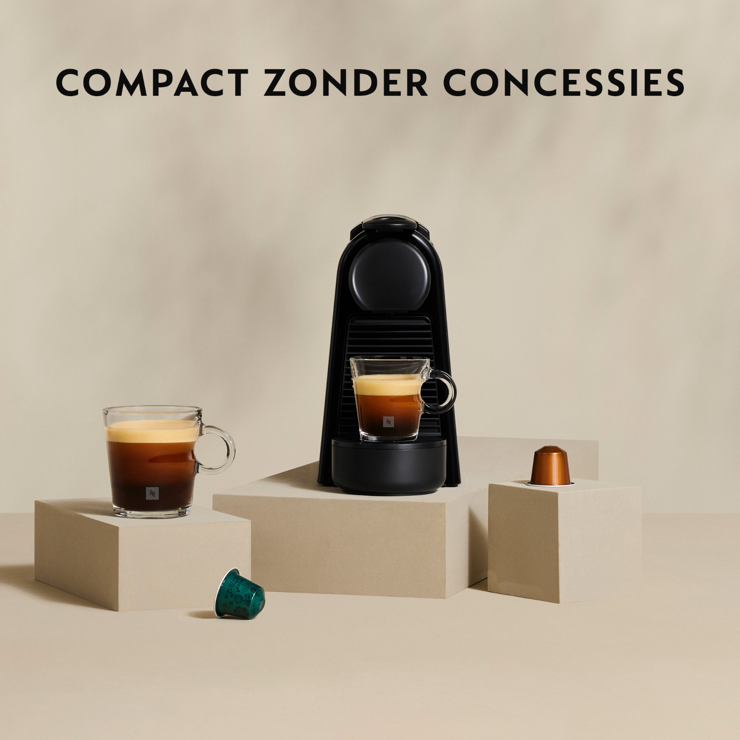 Twee Nespresso-koffies met een zwarte machine, een capsule en de woorden 'Compact zonder concessies'.
