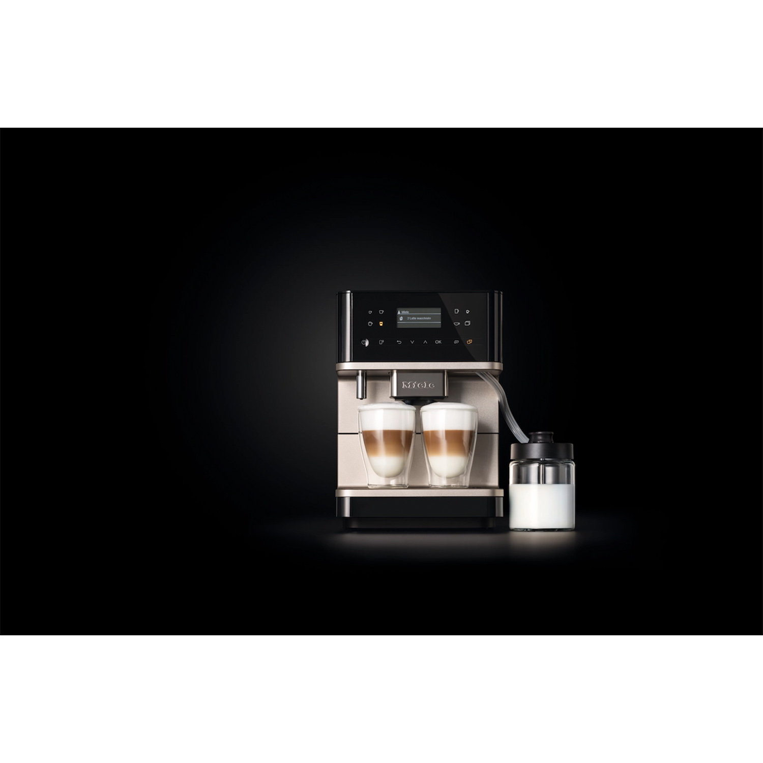 Macchina da caffè con due bicchieri di latte macchiato, contenitore del latte e sfondo nero.