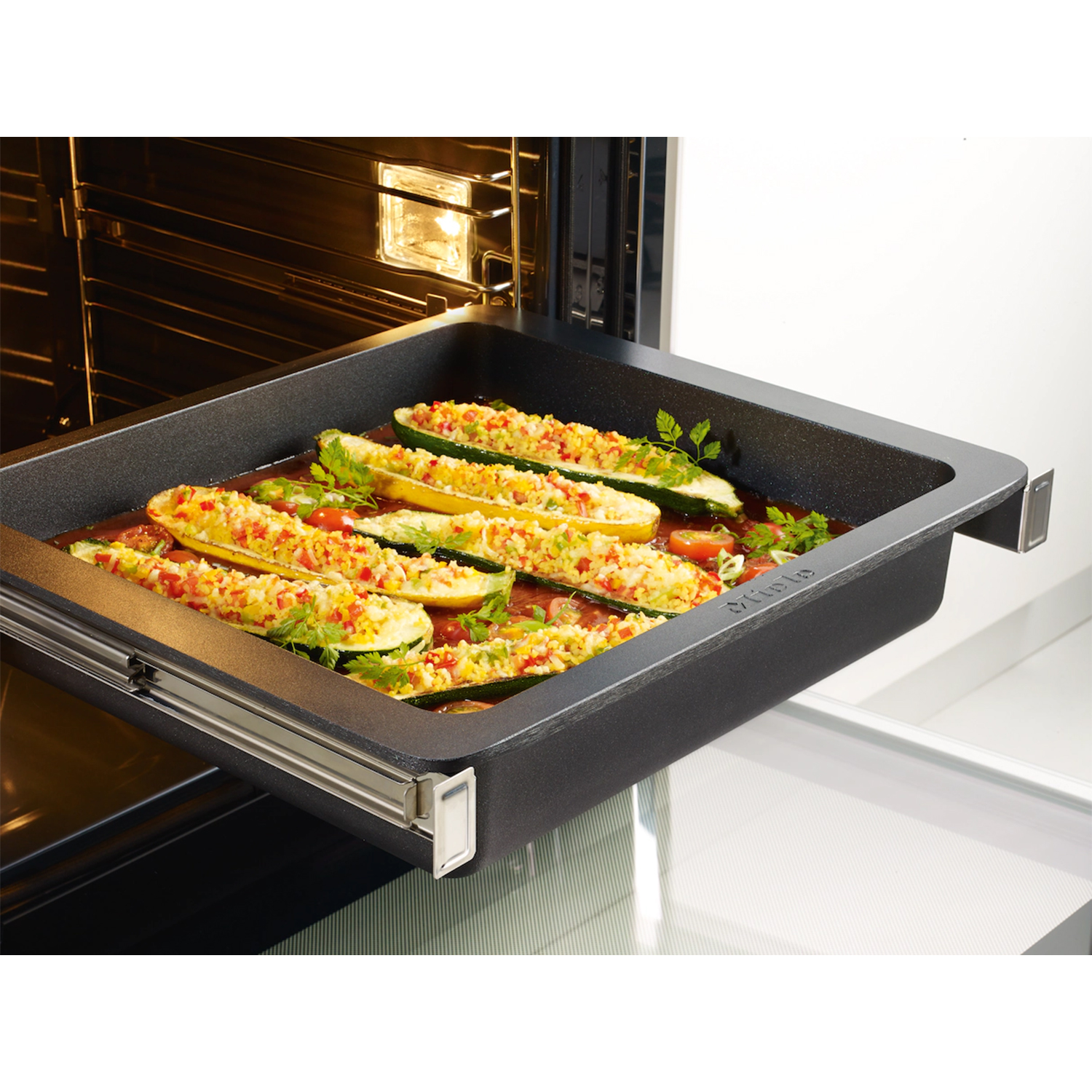 Barchette di zucchine al forno con ripieno in una pirofila nera.