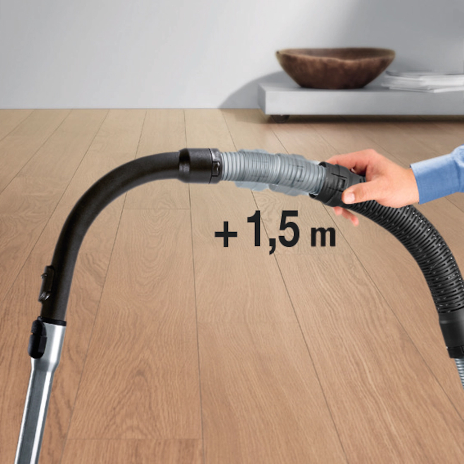 Tubo aspirapolvere con prolunga +1,5 m. Mano che tiene la prolunga collegata.