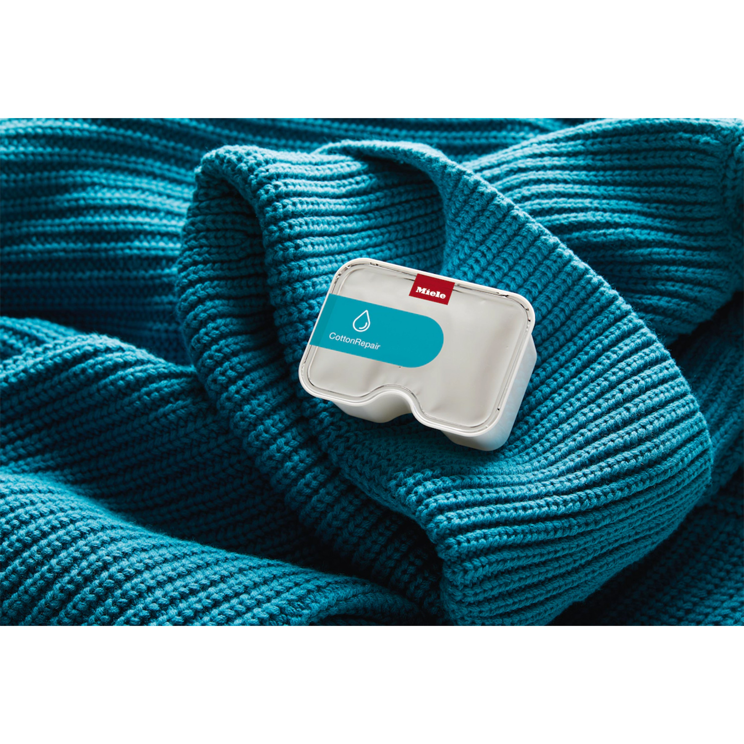 Prodotto bianco Miele per riparazione cotone su tessuto blu a maglia.