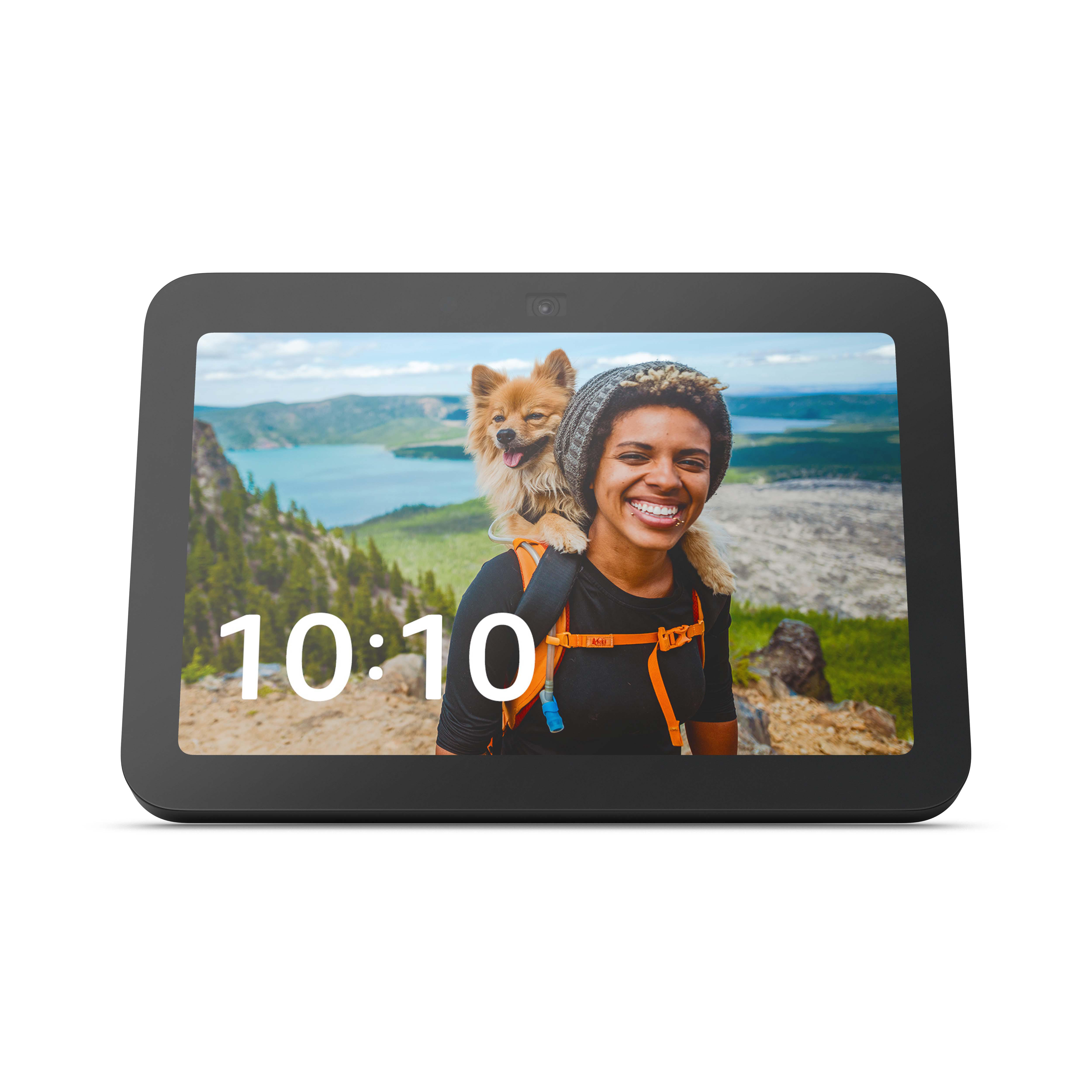 Tablet zeigt Frau und Hund auf einem Berg. Schwarzer Rahmen mit Uhrzeit.