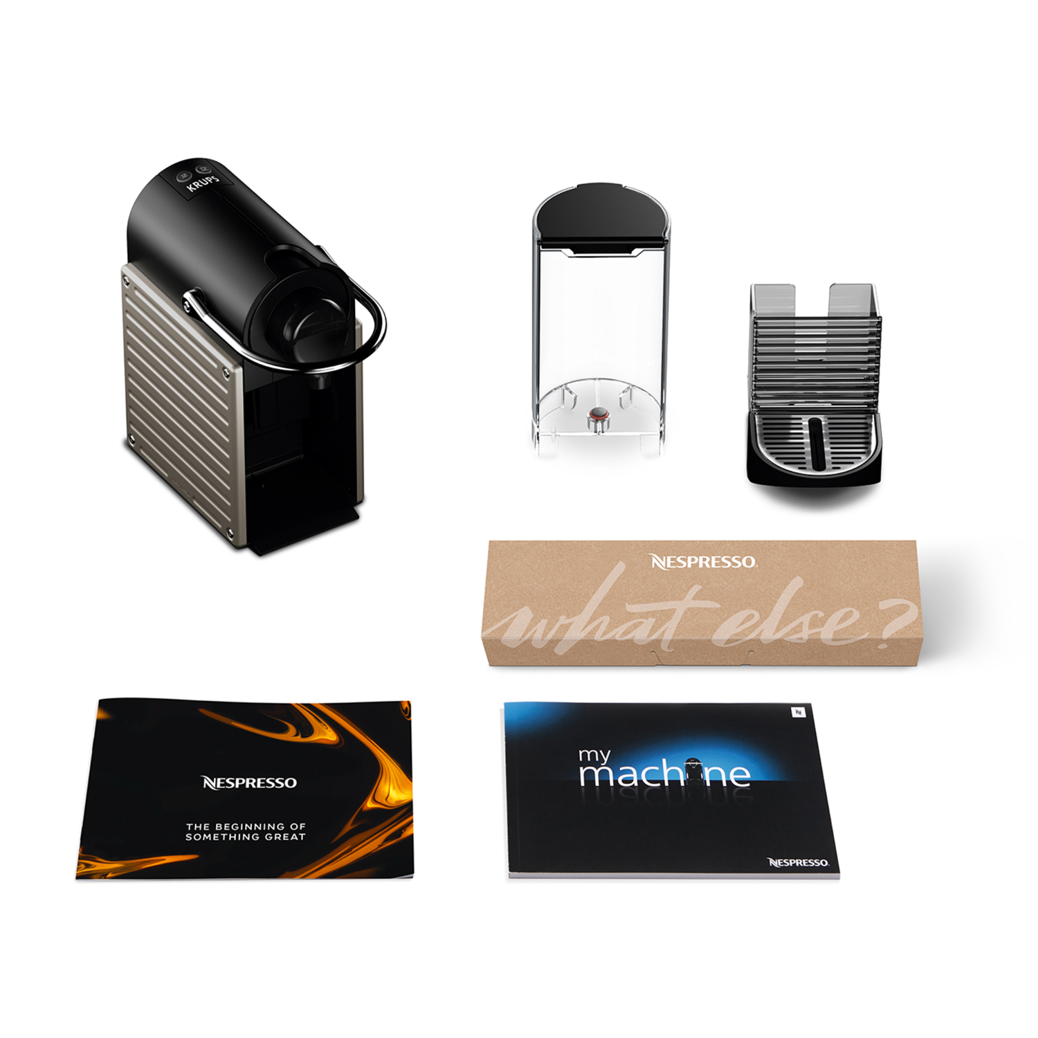 Een zwarte Krups Nespresso machine met aparte onderdelen: watertank, lekbak en twee handleidingen.