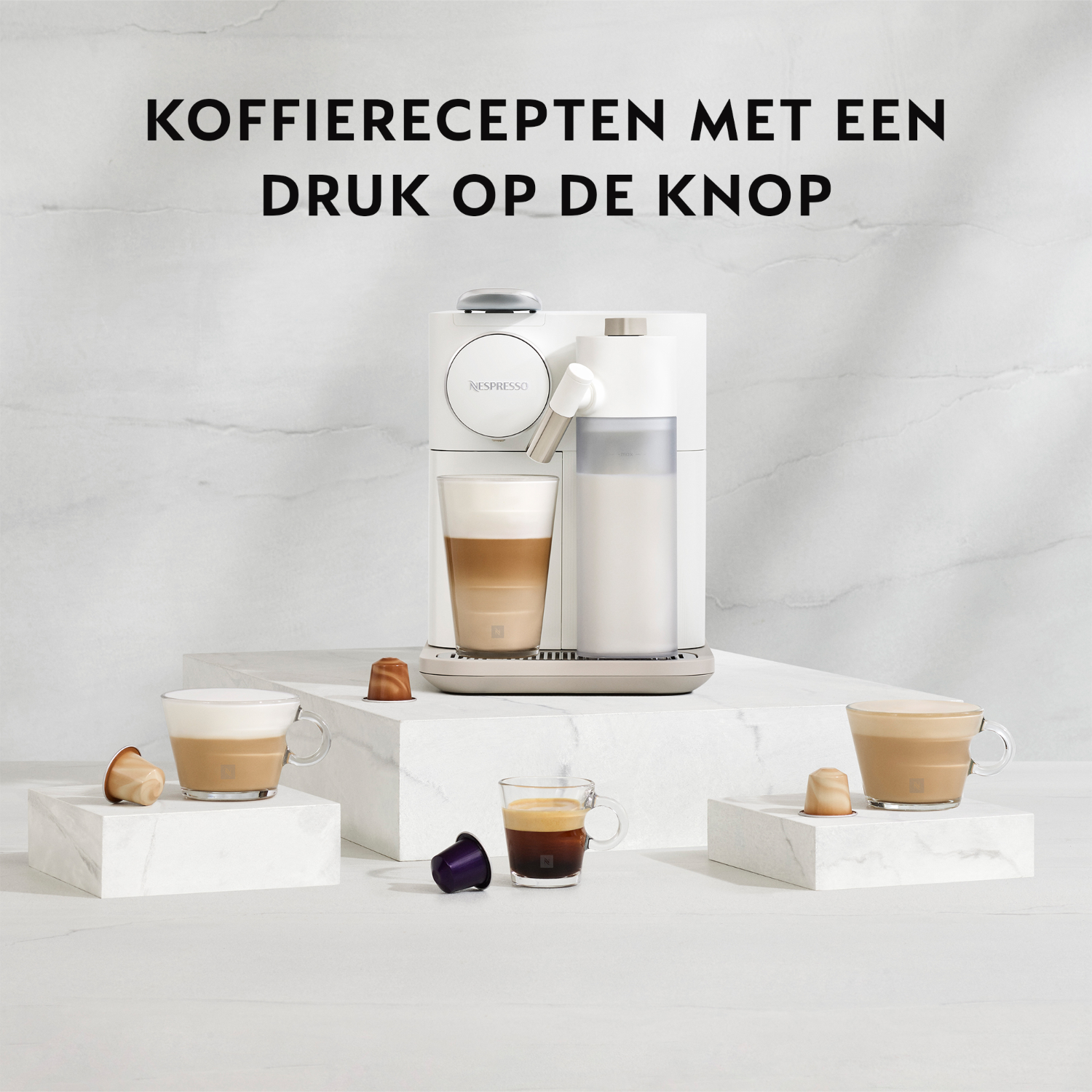 Nespresso coffee machine with cups of coffee and pods.