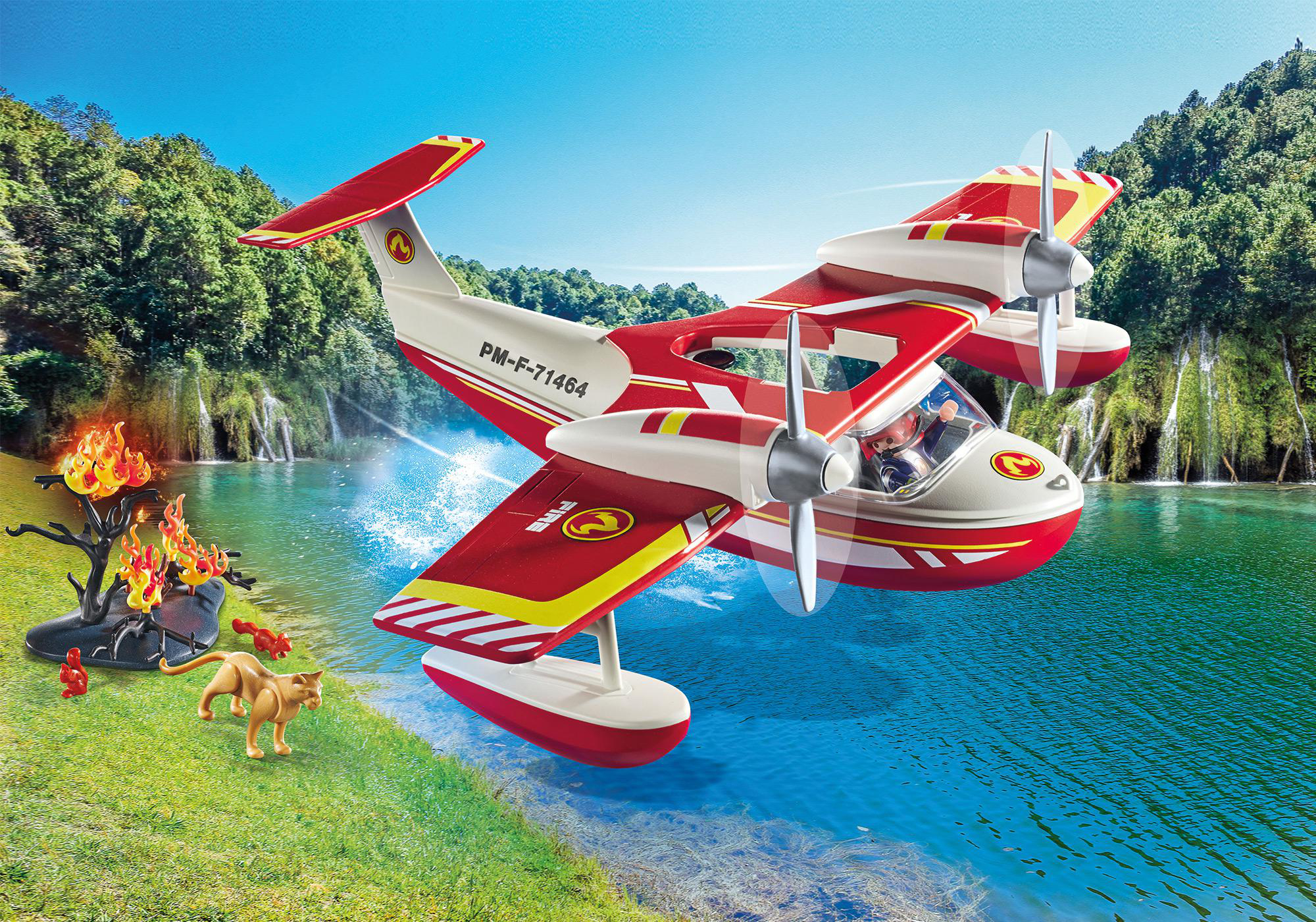 Spielzeug-Wasserflugzeug über Wasser, mit Feuer und Katze am Ufer. Grüne Bäume im Hintergrund.