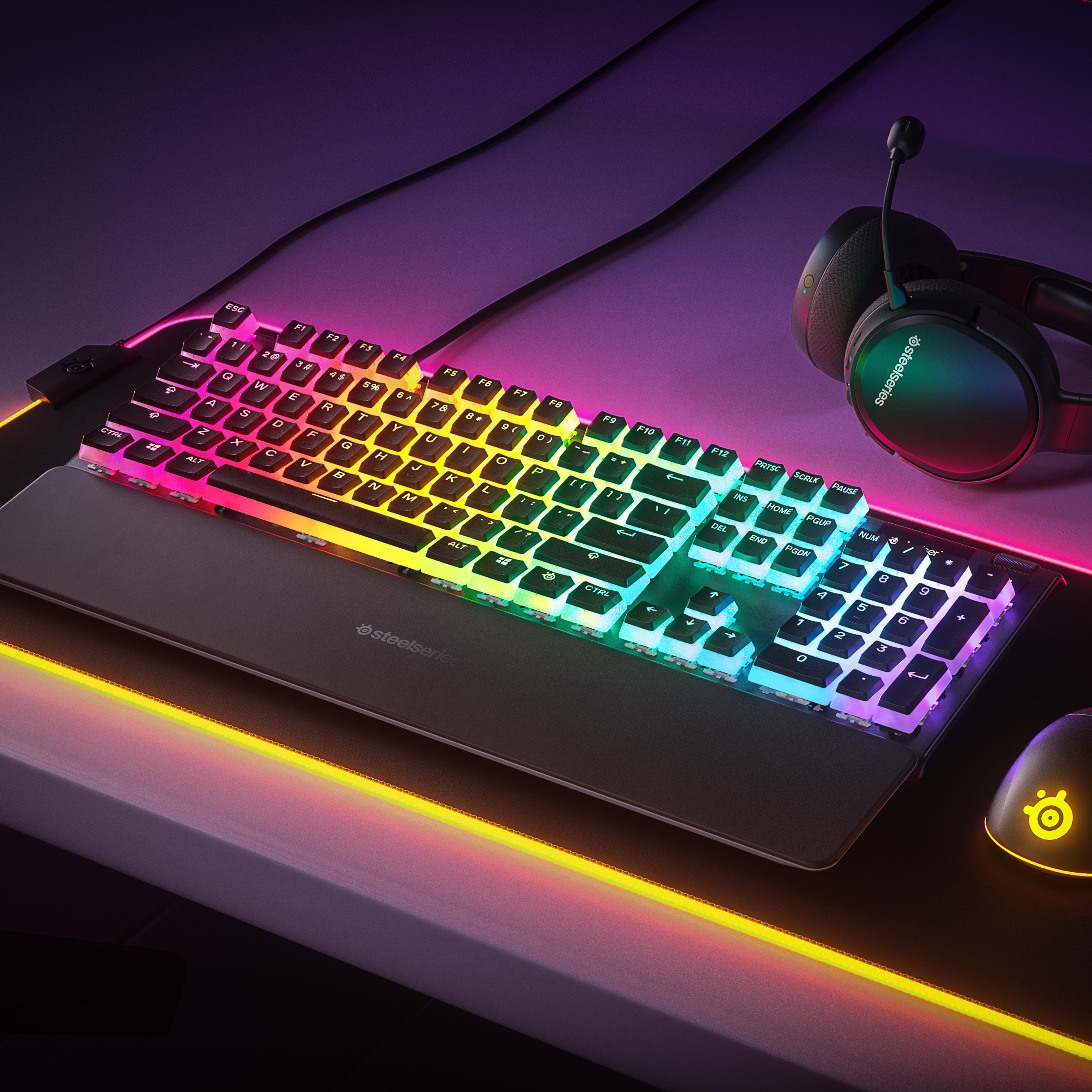 RGB-Hintergrundbeleuchtung Tastatur und Maus auf einem Schreibtisch. Headset liegt auf dem Schreibtisch.