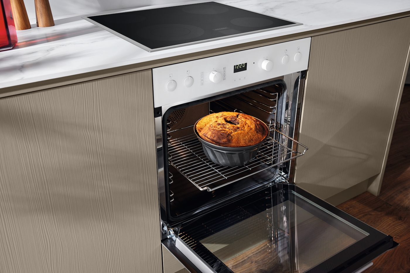 Ein Kuchen im Backofen auf einem Rost. Die Ofentür ist geöffnet.
