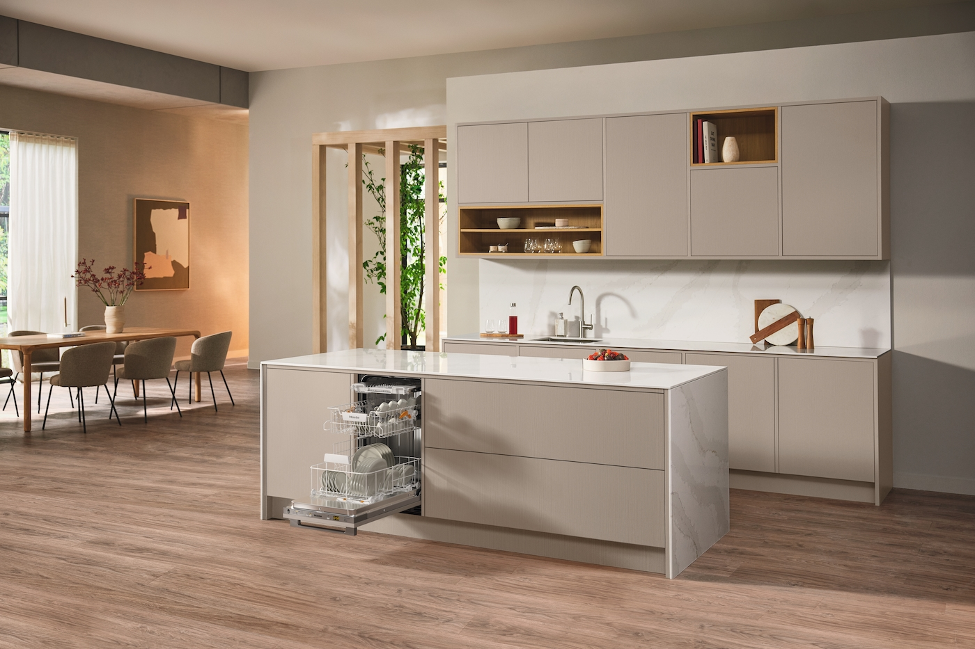 Moderne Küche mit Insel, Spülmaschine offen. Beige Schränke, Holzböden und Fenster.