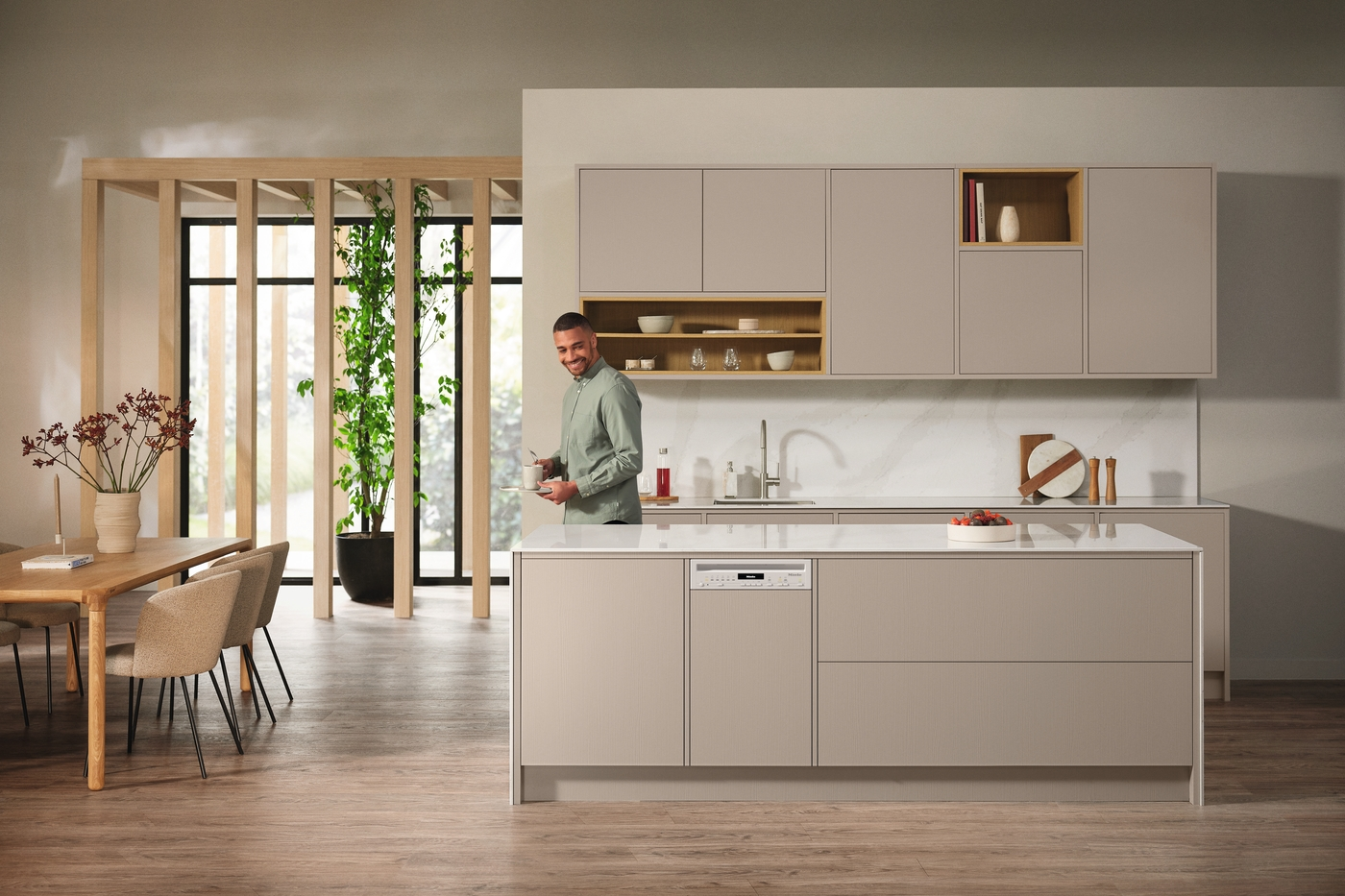 Eine moderne Küche mit einem Mann, der lächelt, eine Tasse hält und einen Geschirrspüler hat.