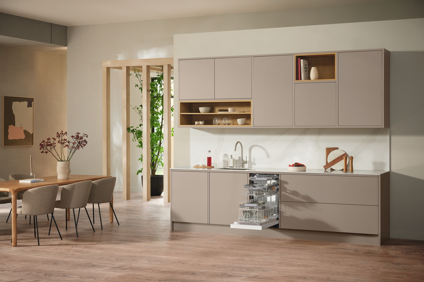 Kücheninterieur mit Geschirrspüler, Schränken und Esstisch.