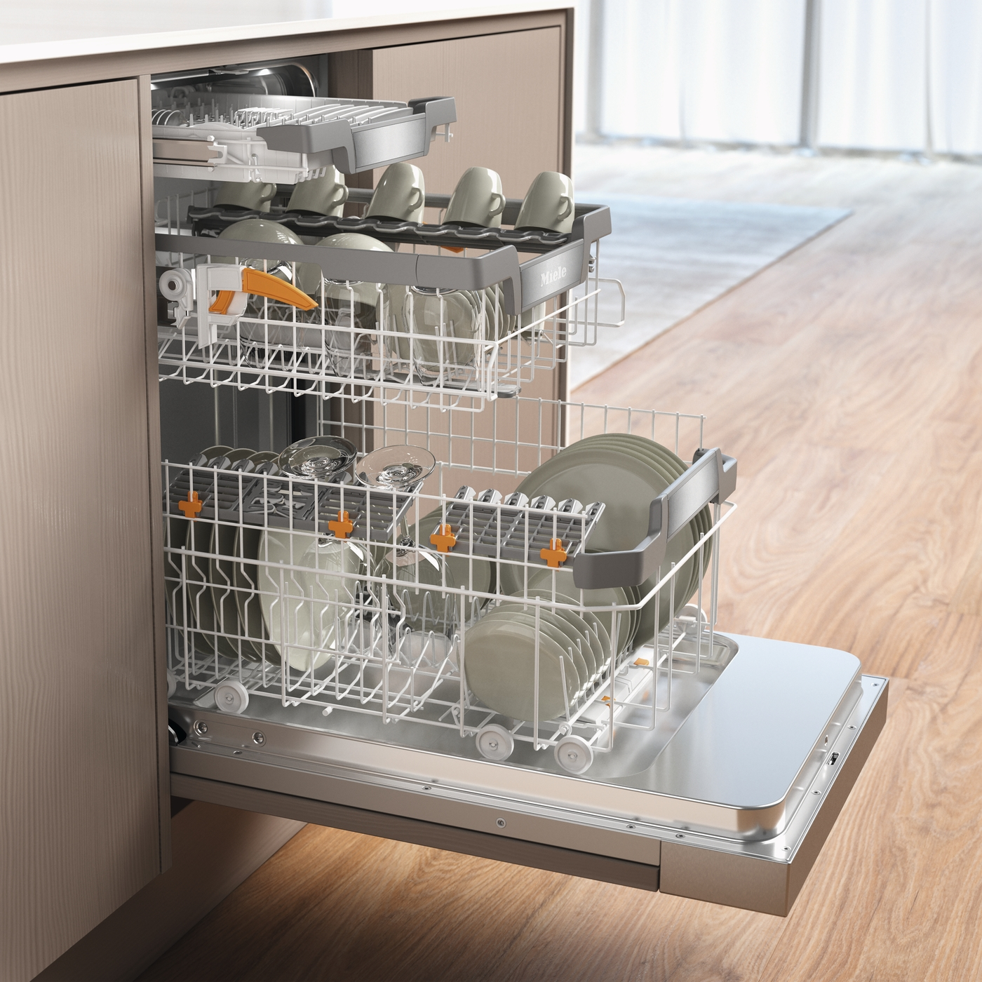 Ein geöffneter Miele-Geschirrspüler, beladen mit Geschirr und Gläsern, in einer Küche.