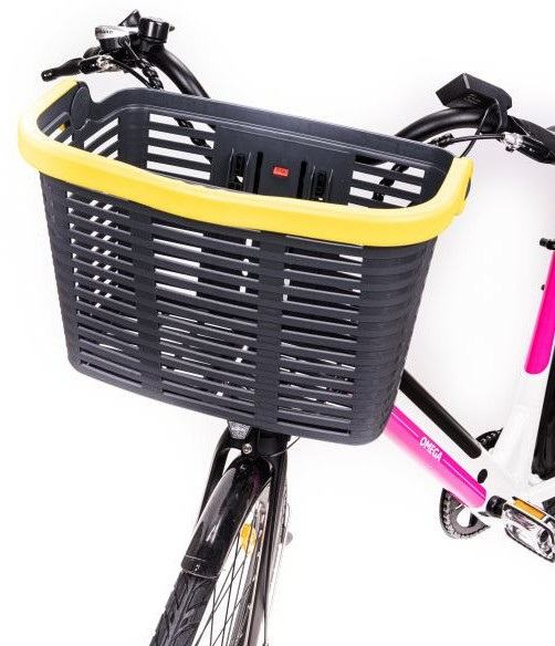 Koszyk rowerowy z żółtą obwódką przymocowany do roweru. Rower jest różowy.