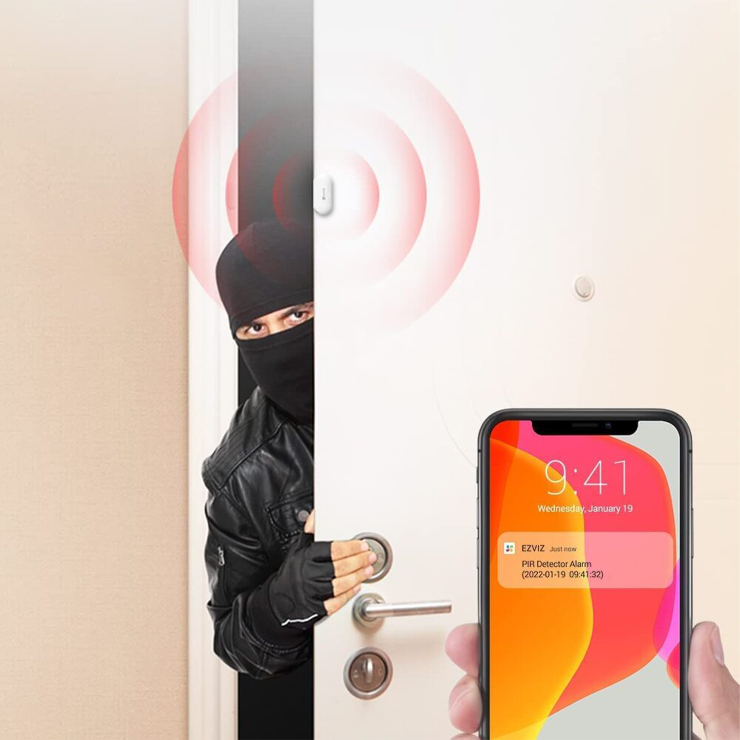 Un ladro sbircia dietro una porta. Un telefono mostra la notifica di un allarme.