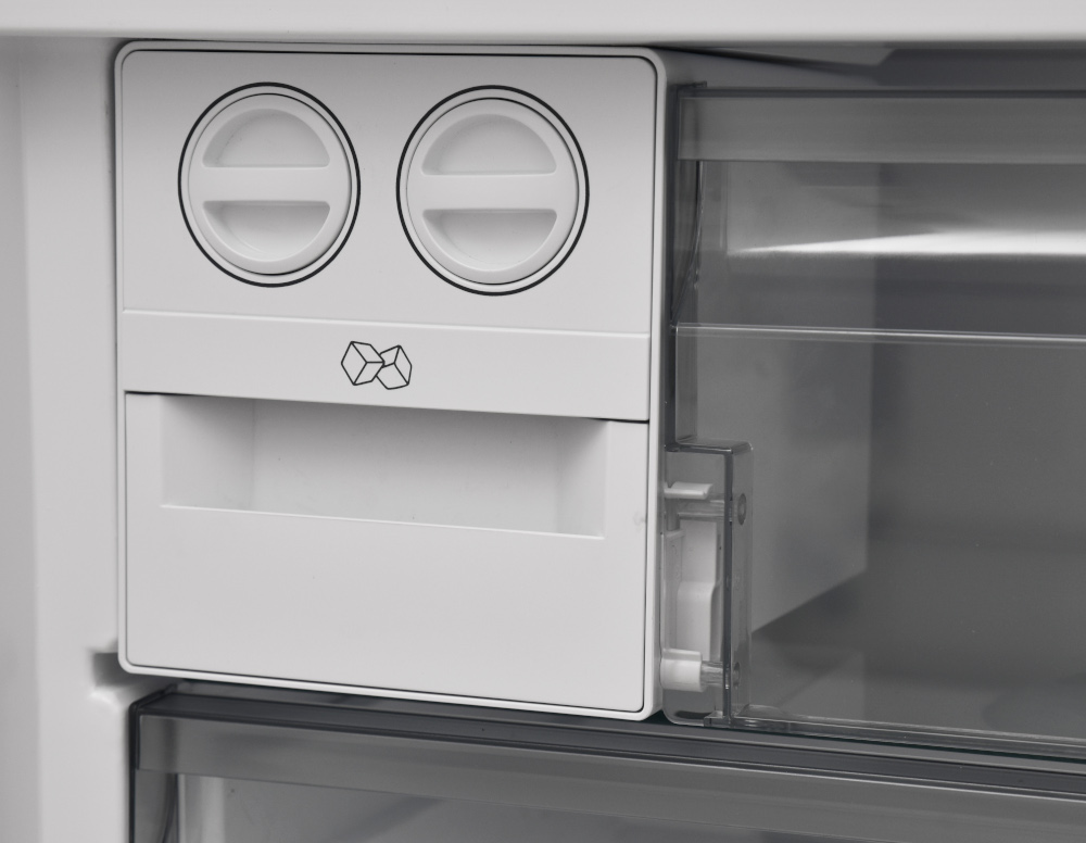 Un compartiment à glaçons et un compartiment dans un réfrigérateur. Plastique blanc et transparent.