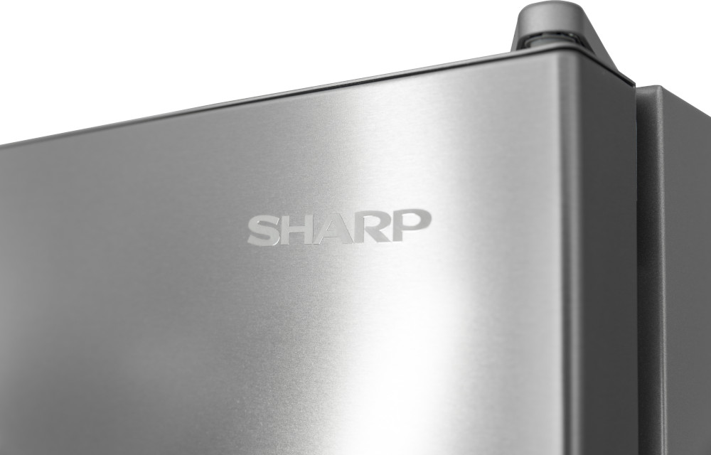 Gros plan sur un réfrigérateur en acier inoxydable avec le logo SHARP visible sur la porte.