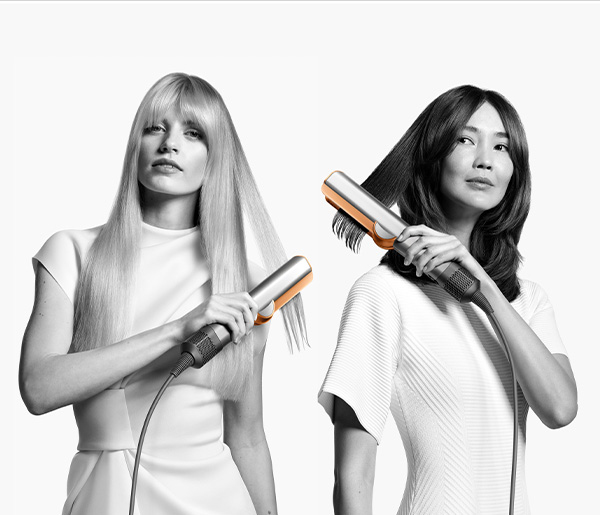 Two women styling their hair with silver and rose gold hair styling tools, white background.