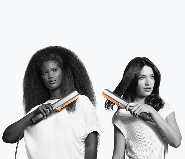 Two women with straighteners. One with afro, one with straight hair. White background.