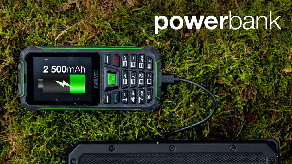 Robosztus telefon töltése mohán, a közelben powerbankkal.