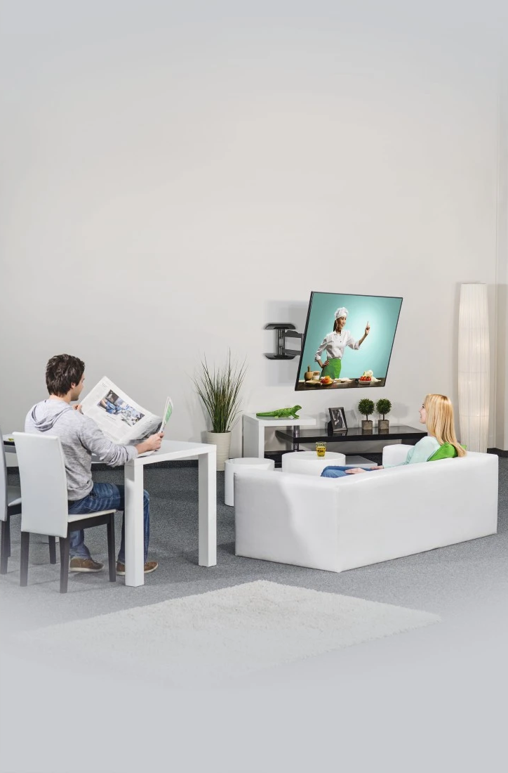 Nappali, TV-vel, amin egy szakács látható, és egy pihenő pár.