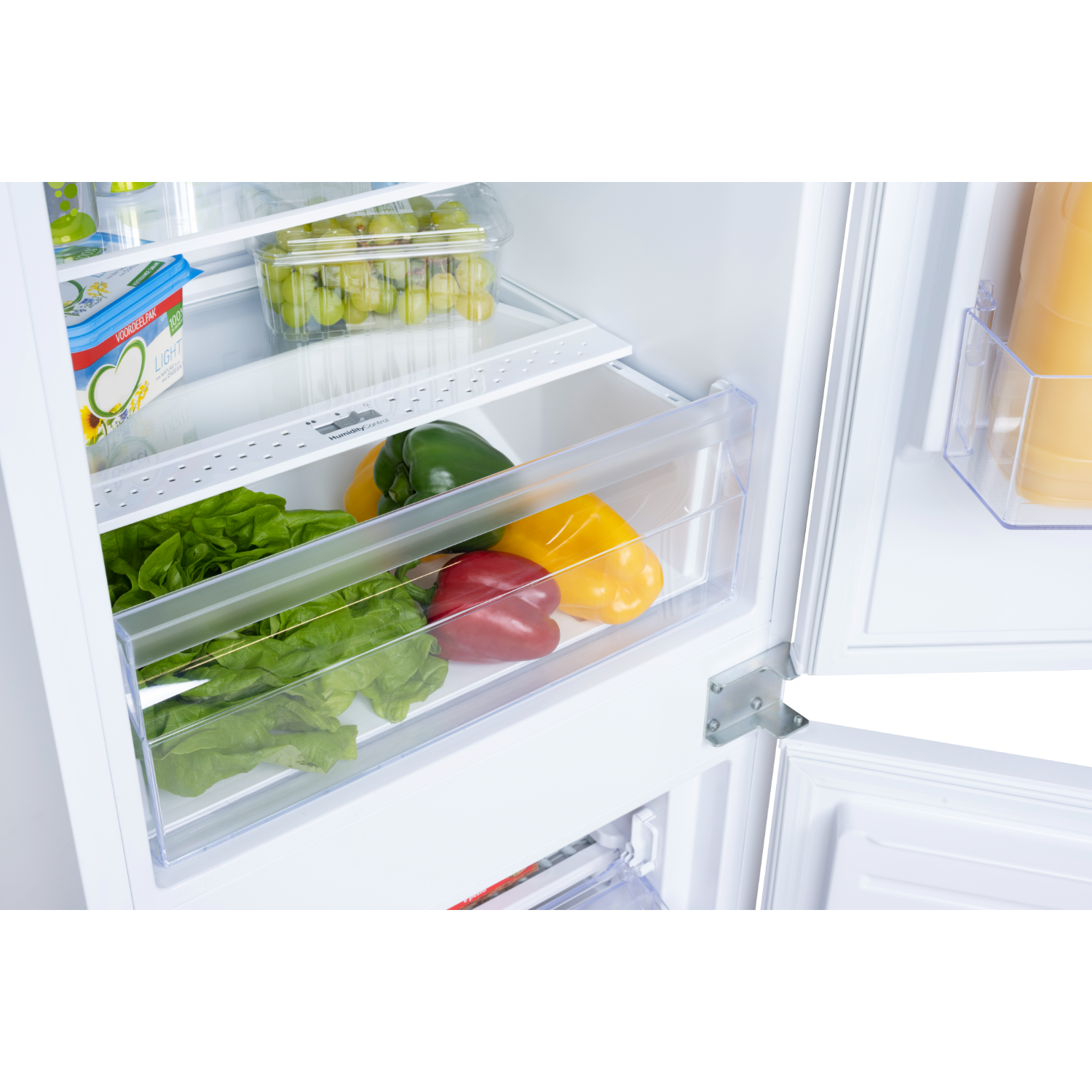 Refrigerator interior with vegetables, fruits, and dairy products.