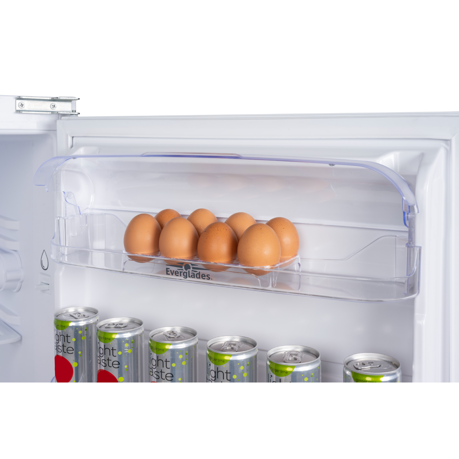 Inside a mini-fridge, clear shelf with eggs and canned drinks. White interior and black background.