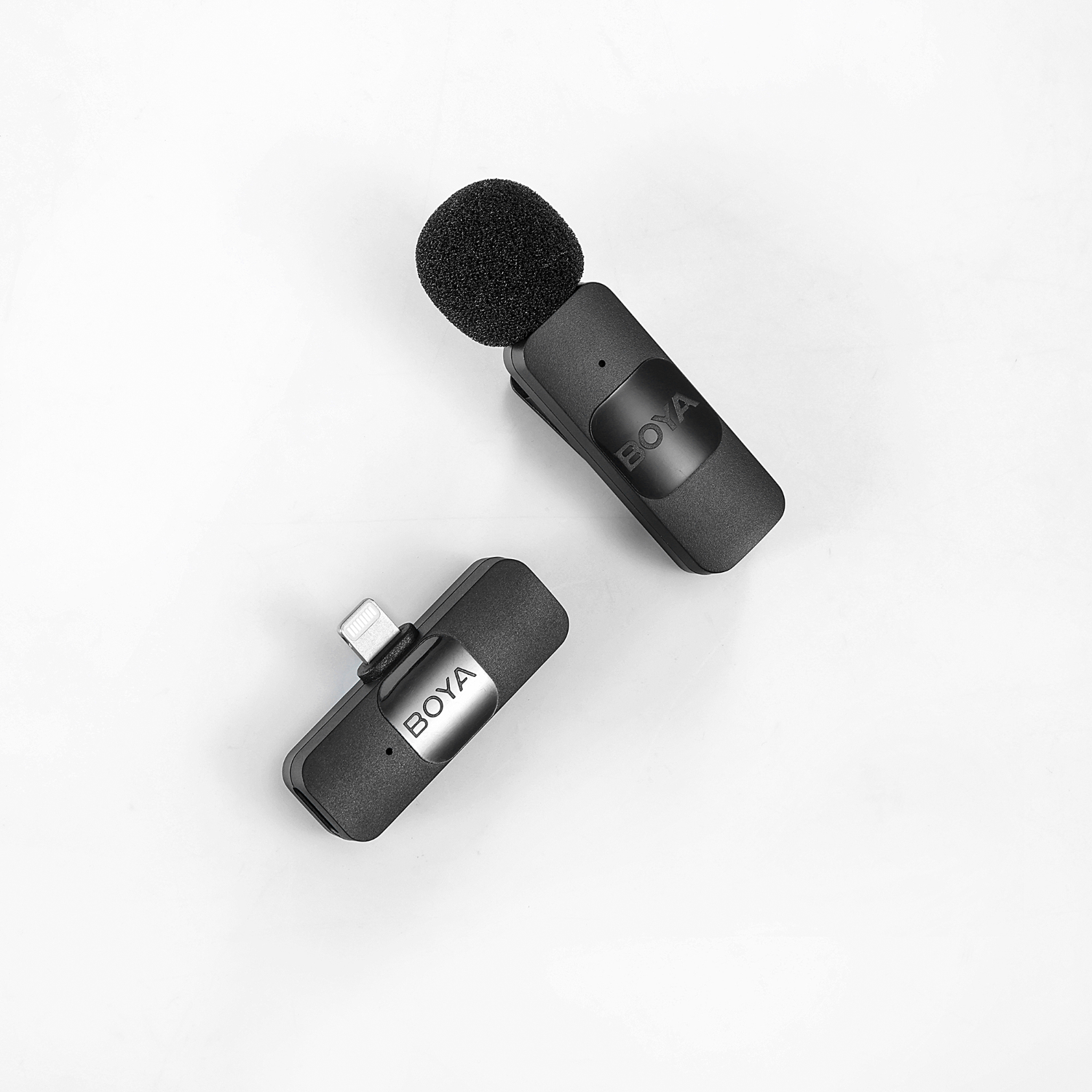 Two black and gray Boya microphones, one with a pop filter, on a white background.