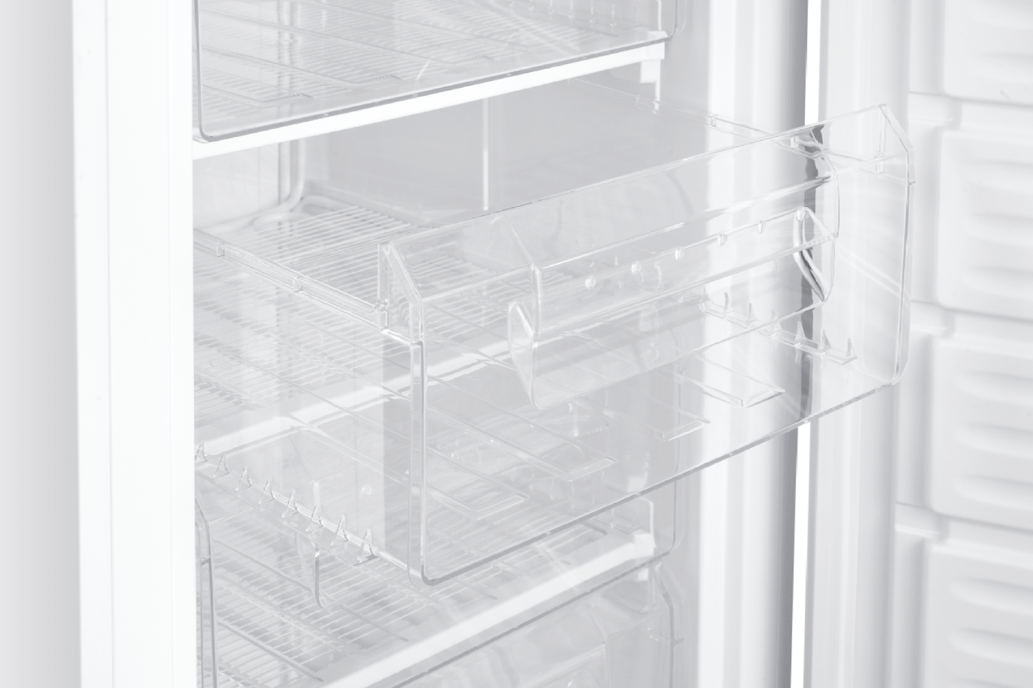 Primer plano del interior de un refrigerador. Se ven estantes de plástico transparente.
