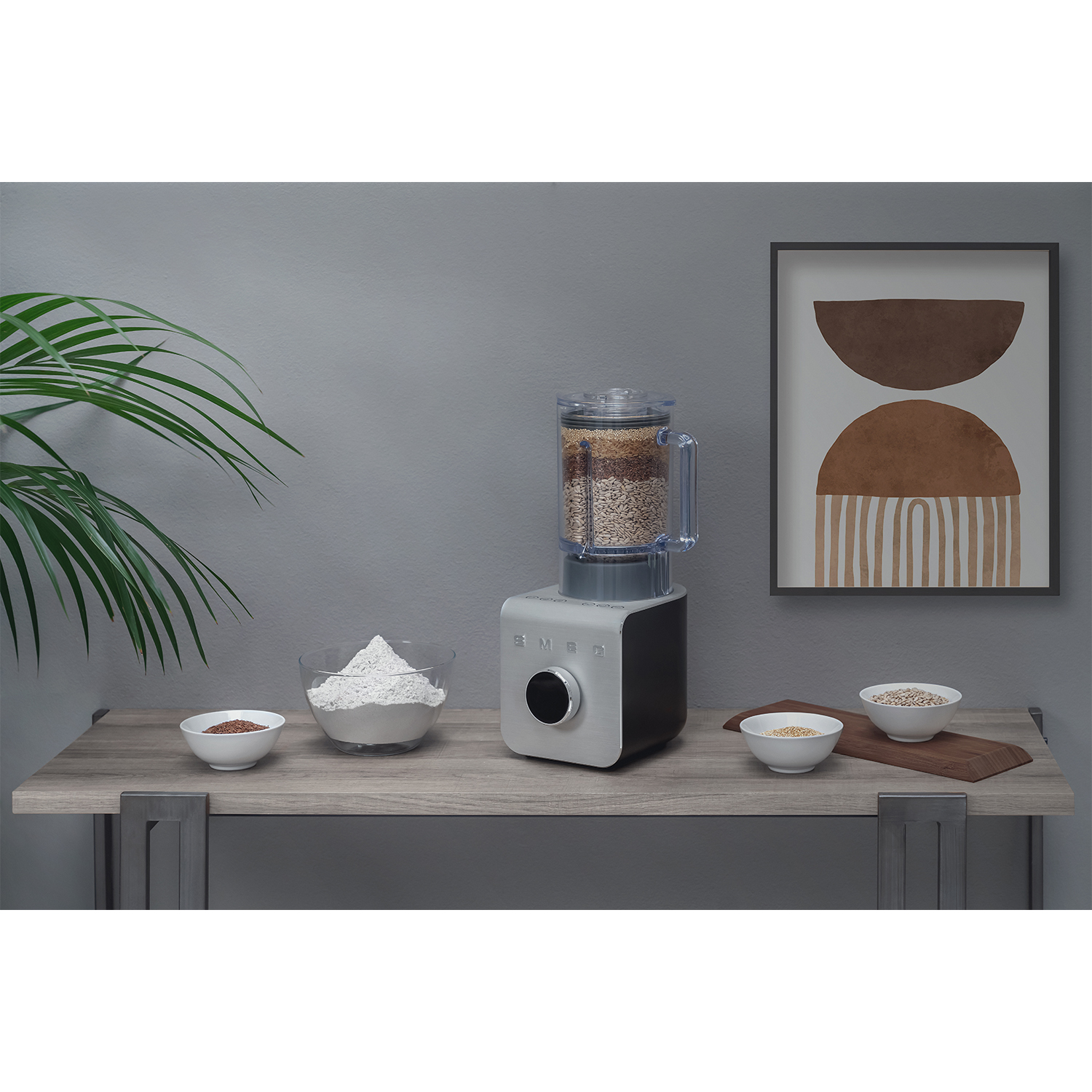 Un robot da cucina con ingredienti, ciotole e un quadro su un tavolo di legno.