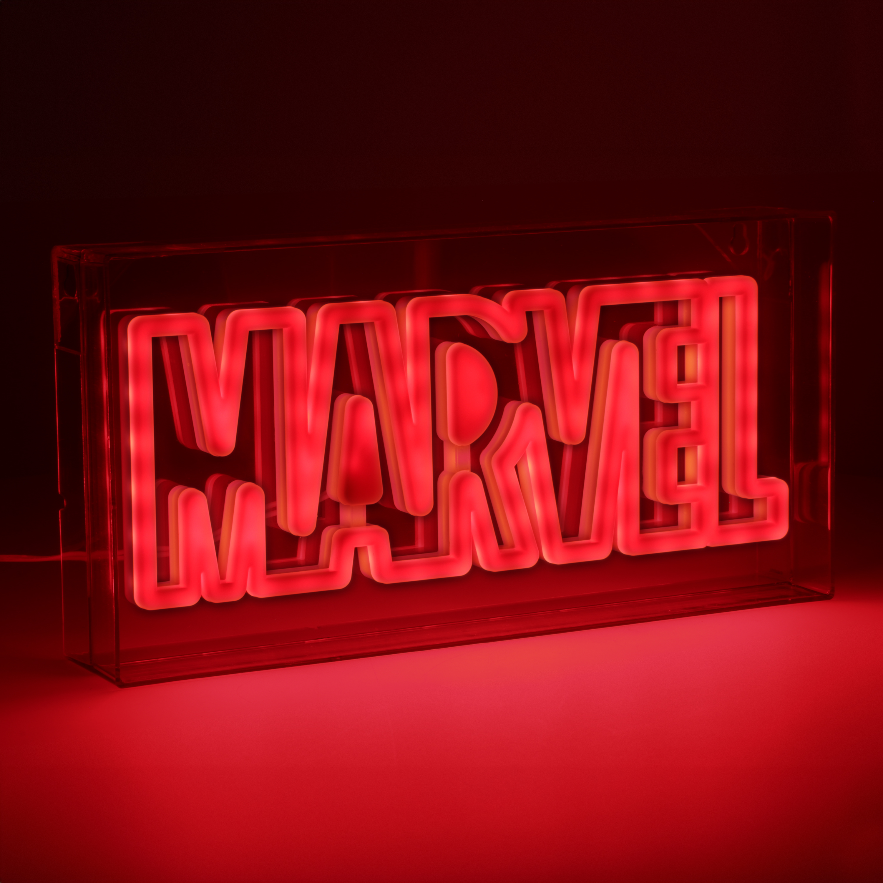 Das Marvel-Logo in rotem Neonlicht in einer durchsichtigen Box, auf roter Oberfläche.