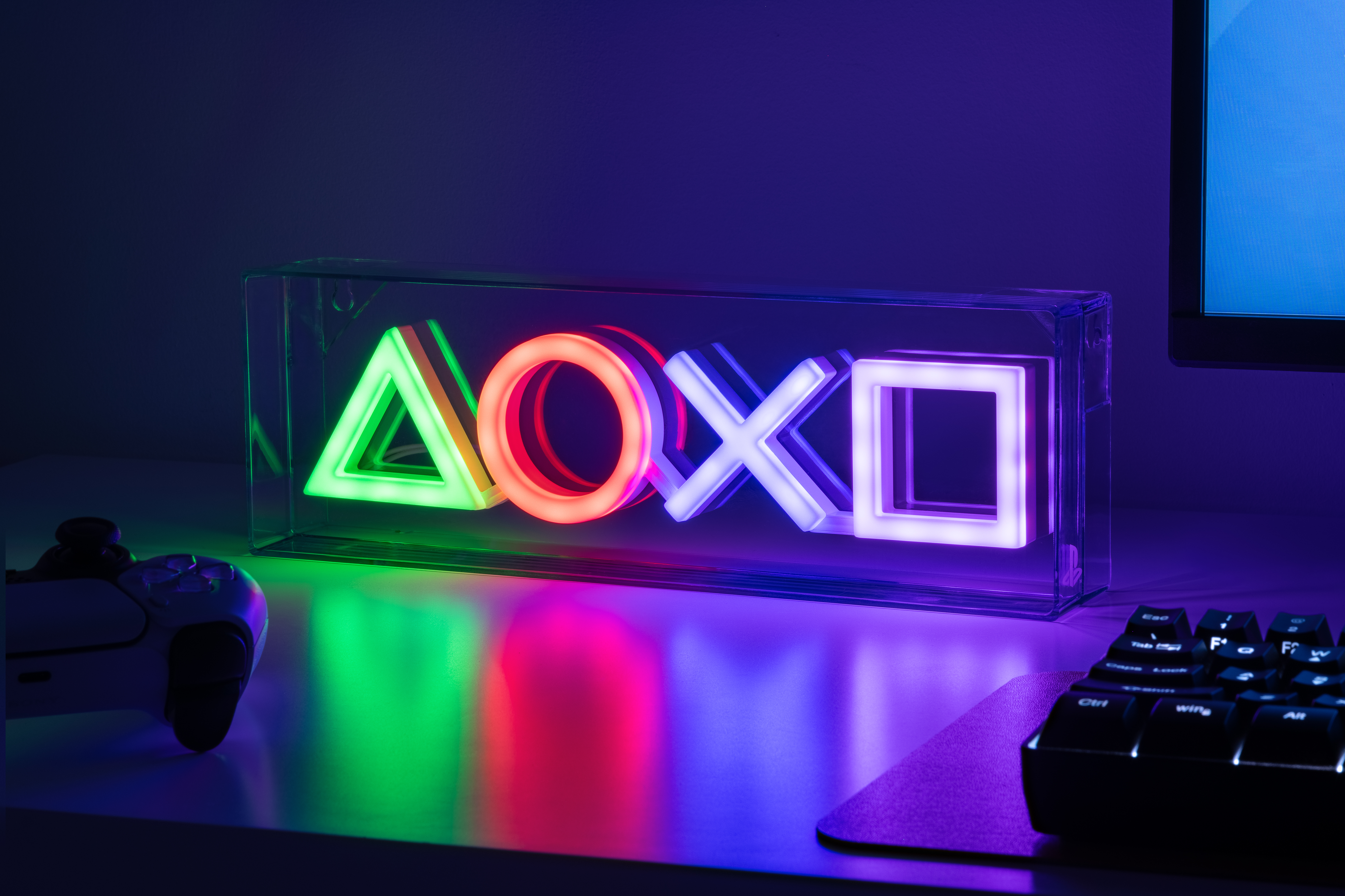PlayStation-Symbol-Leuchten in einer durchsichtigen Box auf einem Schreibtisch.