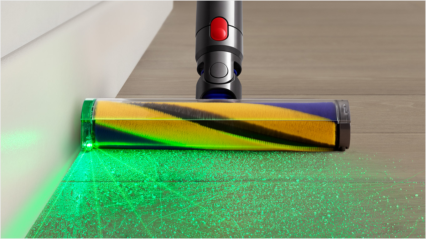 Głowica odkurzacza z zielonym światłem na drewnianej podłodze.