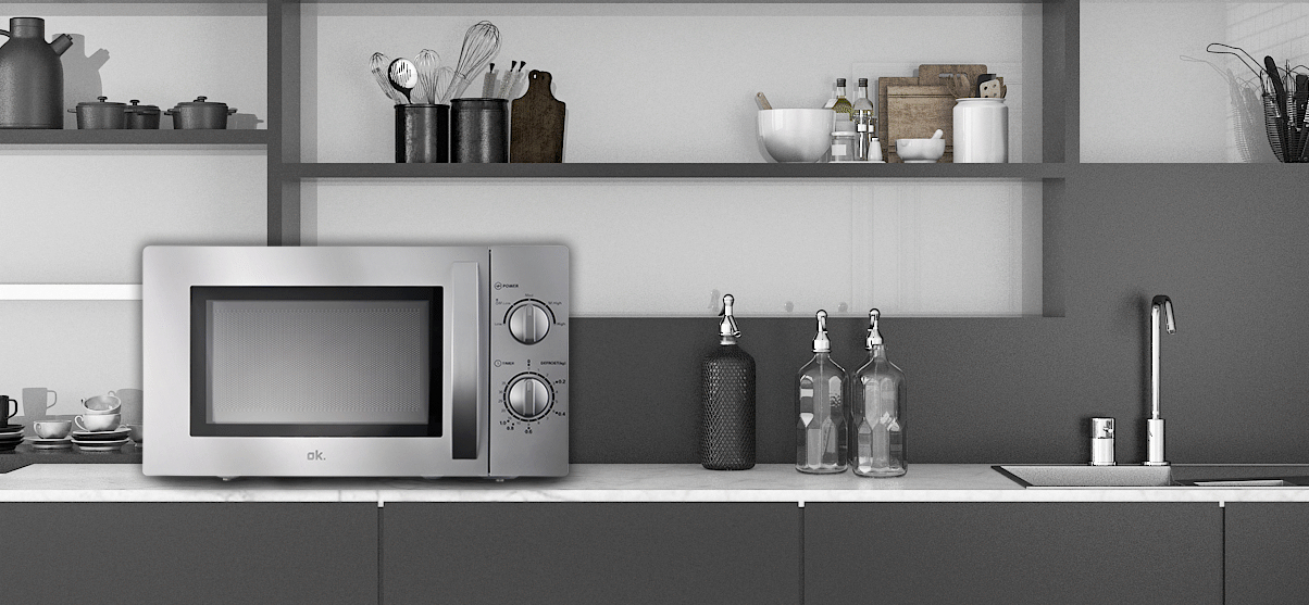 Mikrowelle auf einer Arbeitsplatte. Küchenutensilien und Deko sind im Hintergrund.