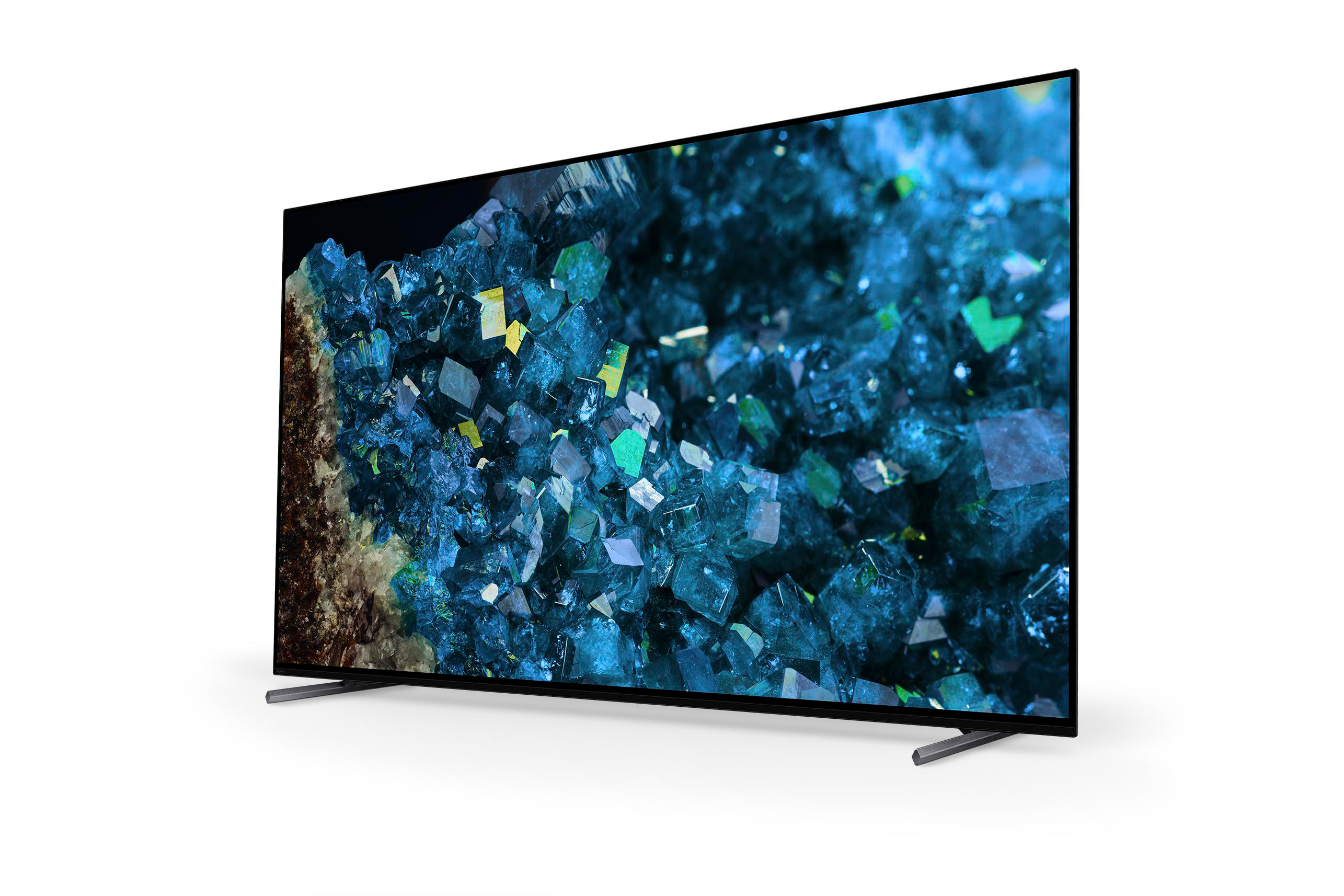 Ein schwarz gerahmter Fernseher zeigt ein blau-grünes mineralartiges Muster. Der Fernseher steht auf silbernen Beinen.