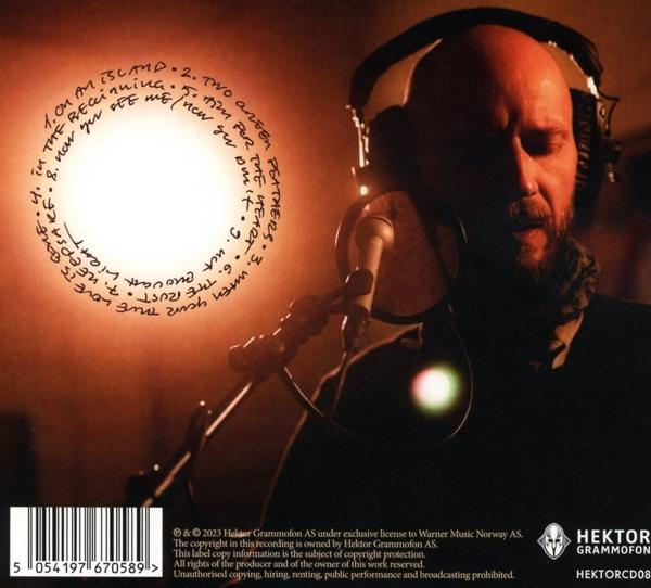 Ein Mann singt in ein Mikrofon, Text um einen Kreis.